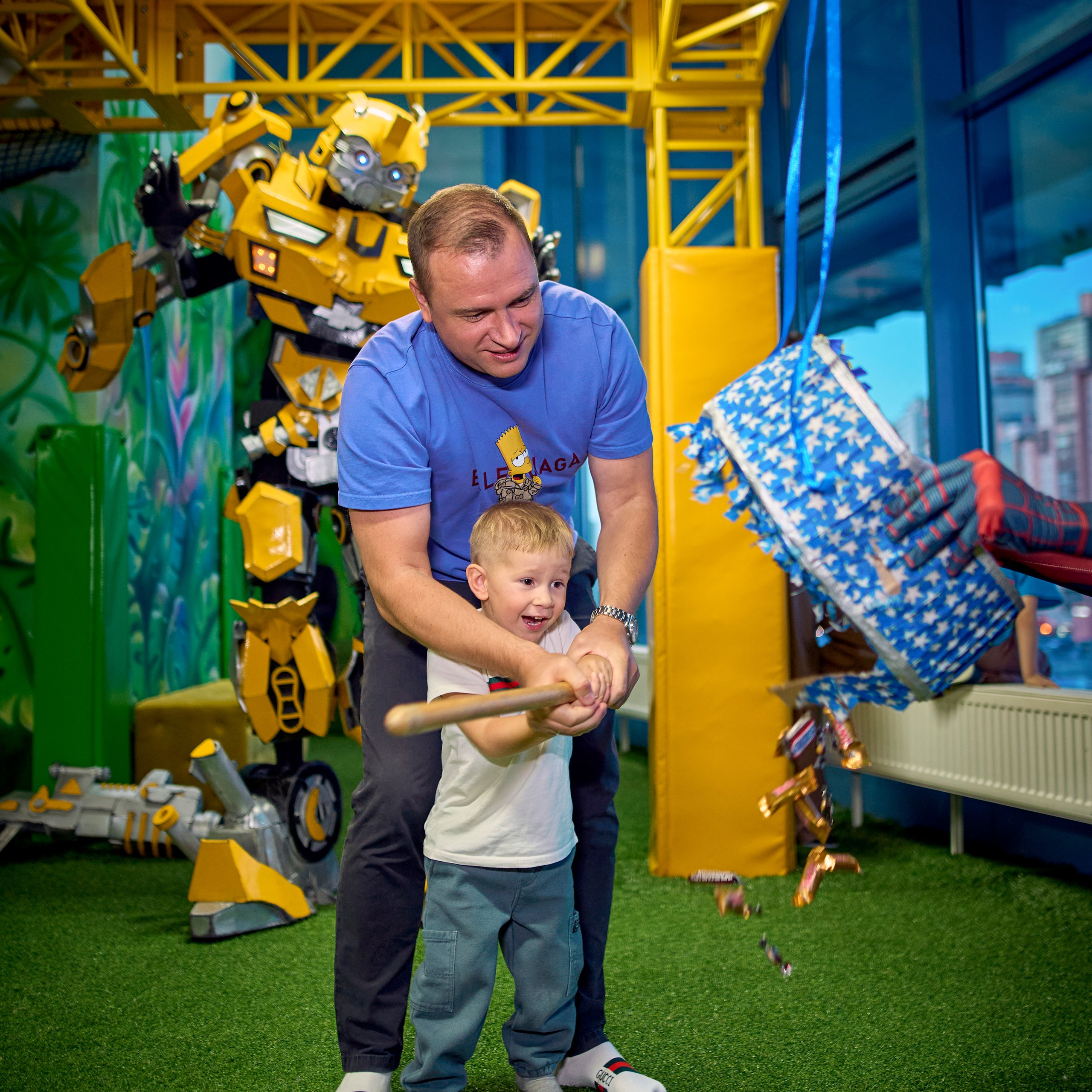 Папа помогает своему ребенку разбить пиньяту