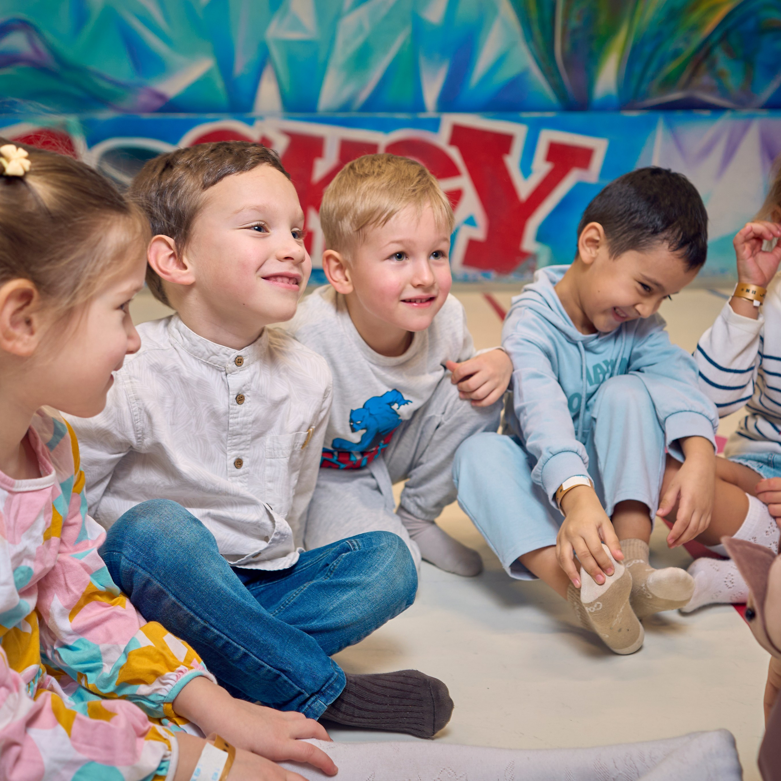 Дети улыбаются сидя на полу