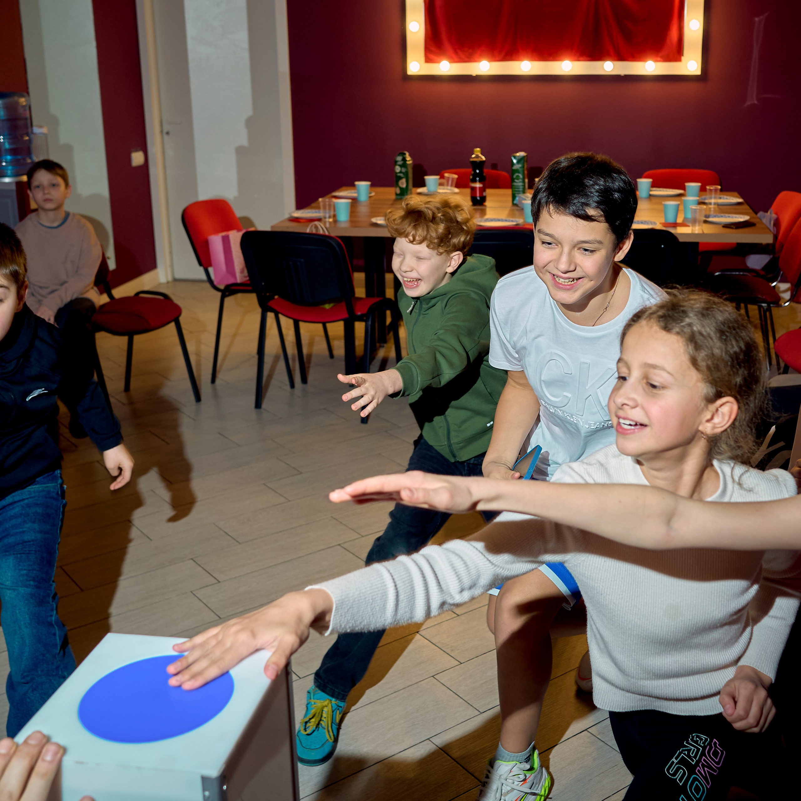 Дети на перегонки нажимают на синюю кнопку