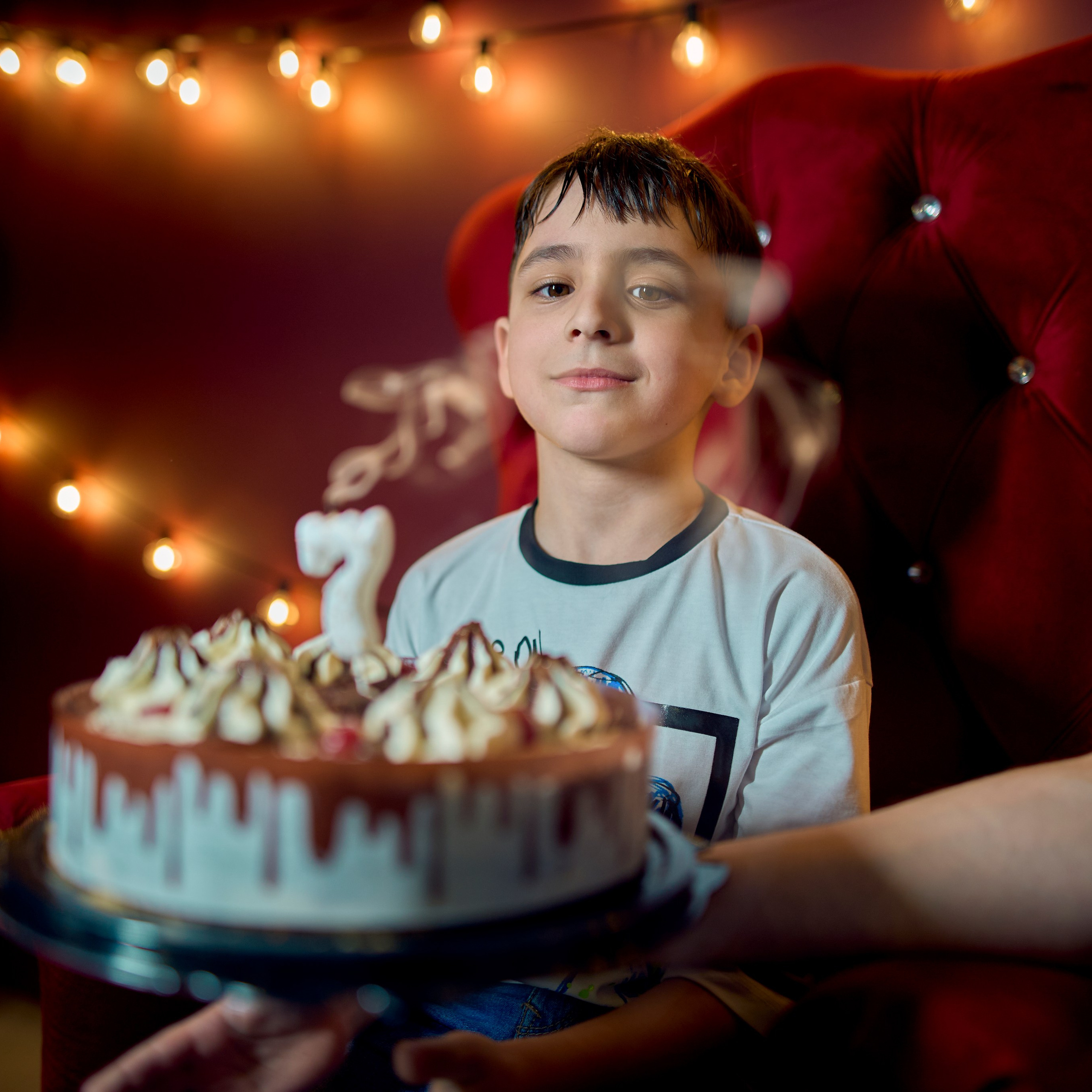 Мальчик задувает свечи, дым от свечей