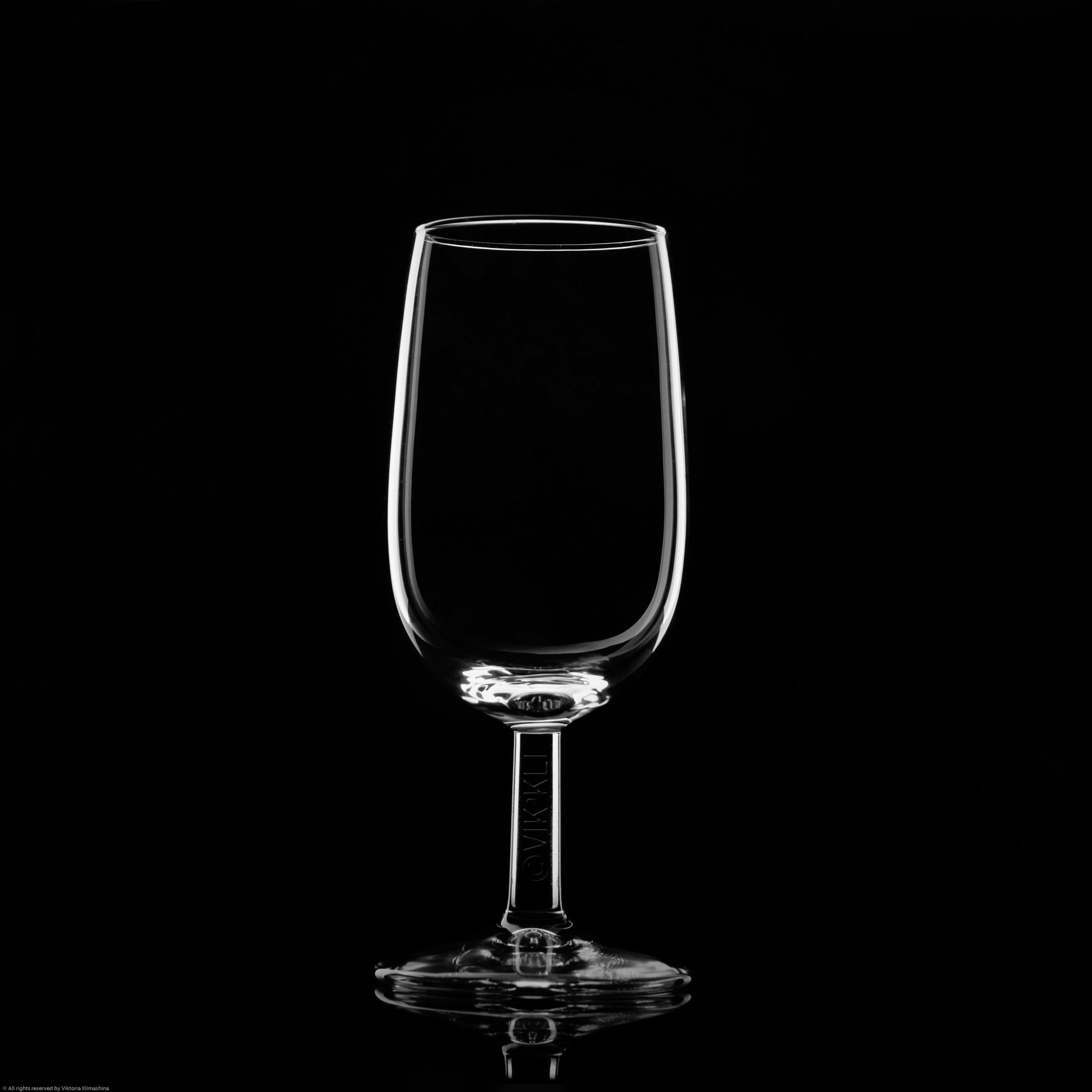 Стеклянный бокал на чёрном фоне. Предметное фото.