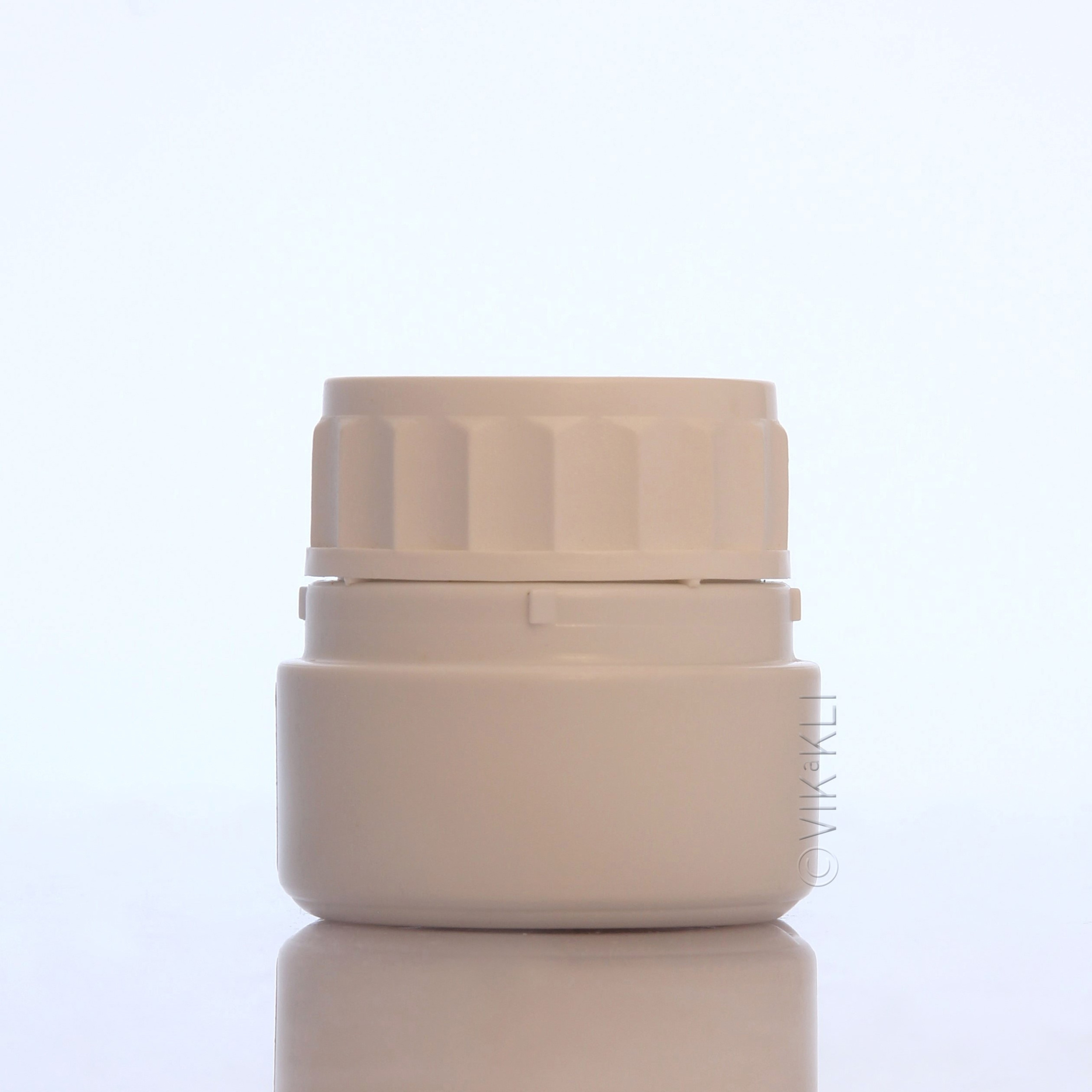 Белая баночка на белом фоне с отражением. Предметное фото.