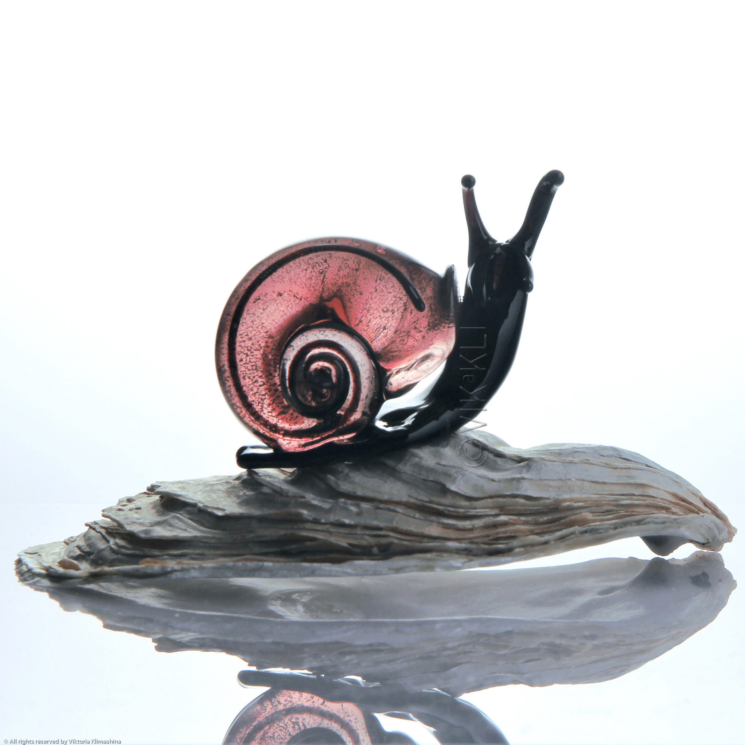Улитка из муранского стекла на белом фоне. Предметное фото..