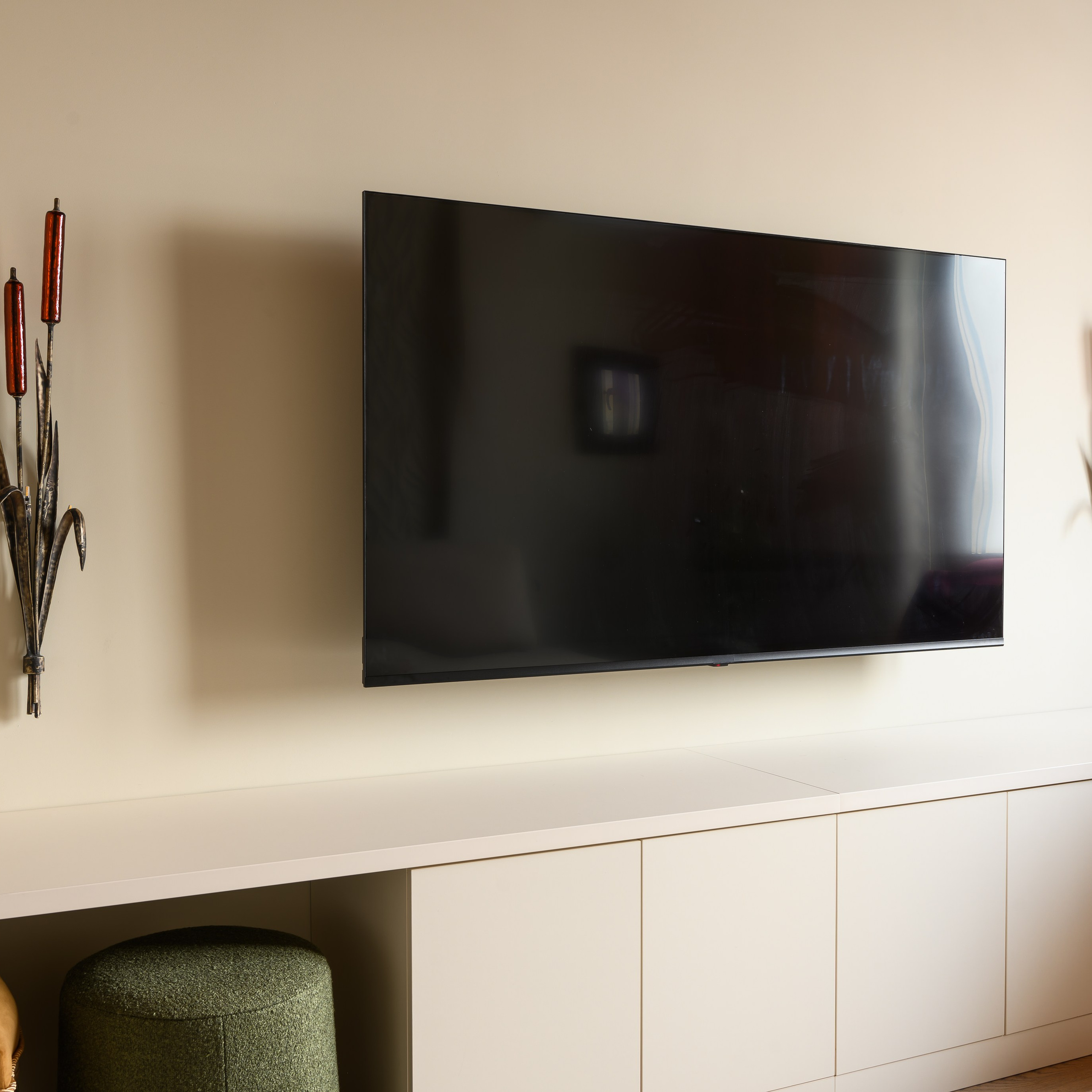 Между настенными светильниками на кронштейне закрепили телевизор с диагональю 165 см