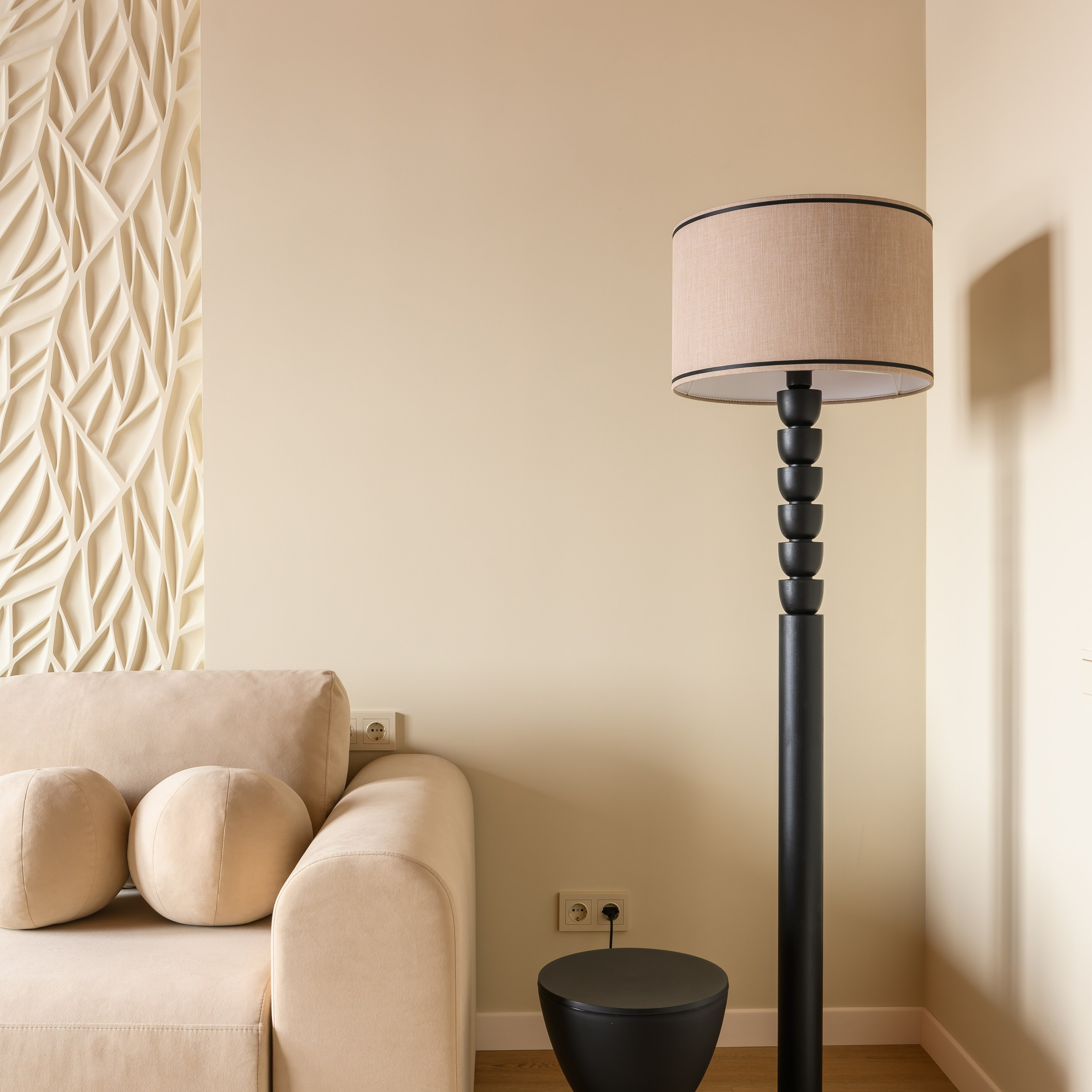 Рядом с диваном встал торшер, выполненный мастером Юлией Аршиновой. Ногу из массива бука в черной эмали венчает абажур из рогожки. 