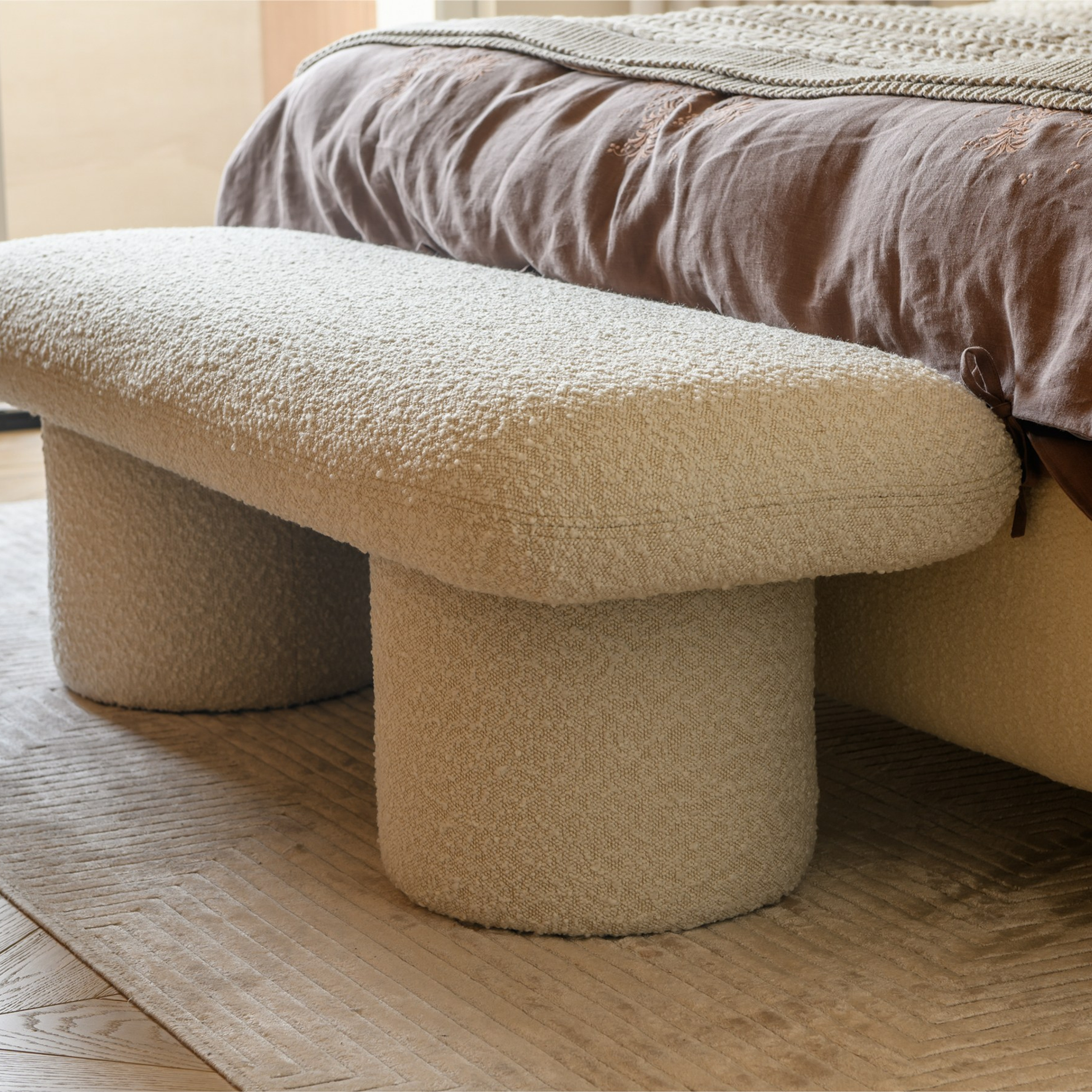 Компаньоном кровати выступает эффектная банкетка обтекаемой формы в обивке букле на классных фотографиях интерьерного фотографа Сапожникова Георгия.