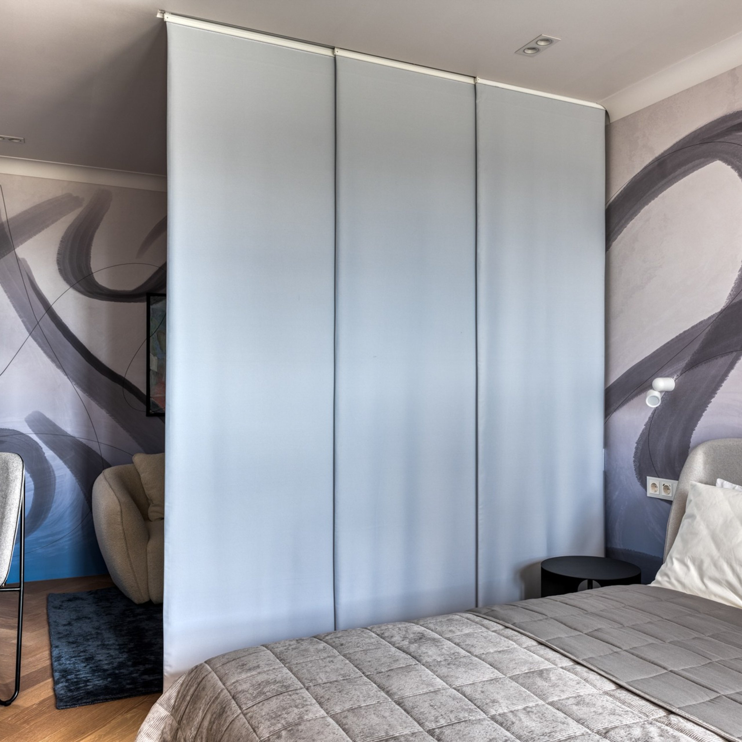 Альтернативой телевизору, который был у наших героев, стал проектор, а в качестве экрана выступает японская штора, которая делит комнату на зоны гостиной и приватное пространство.