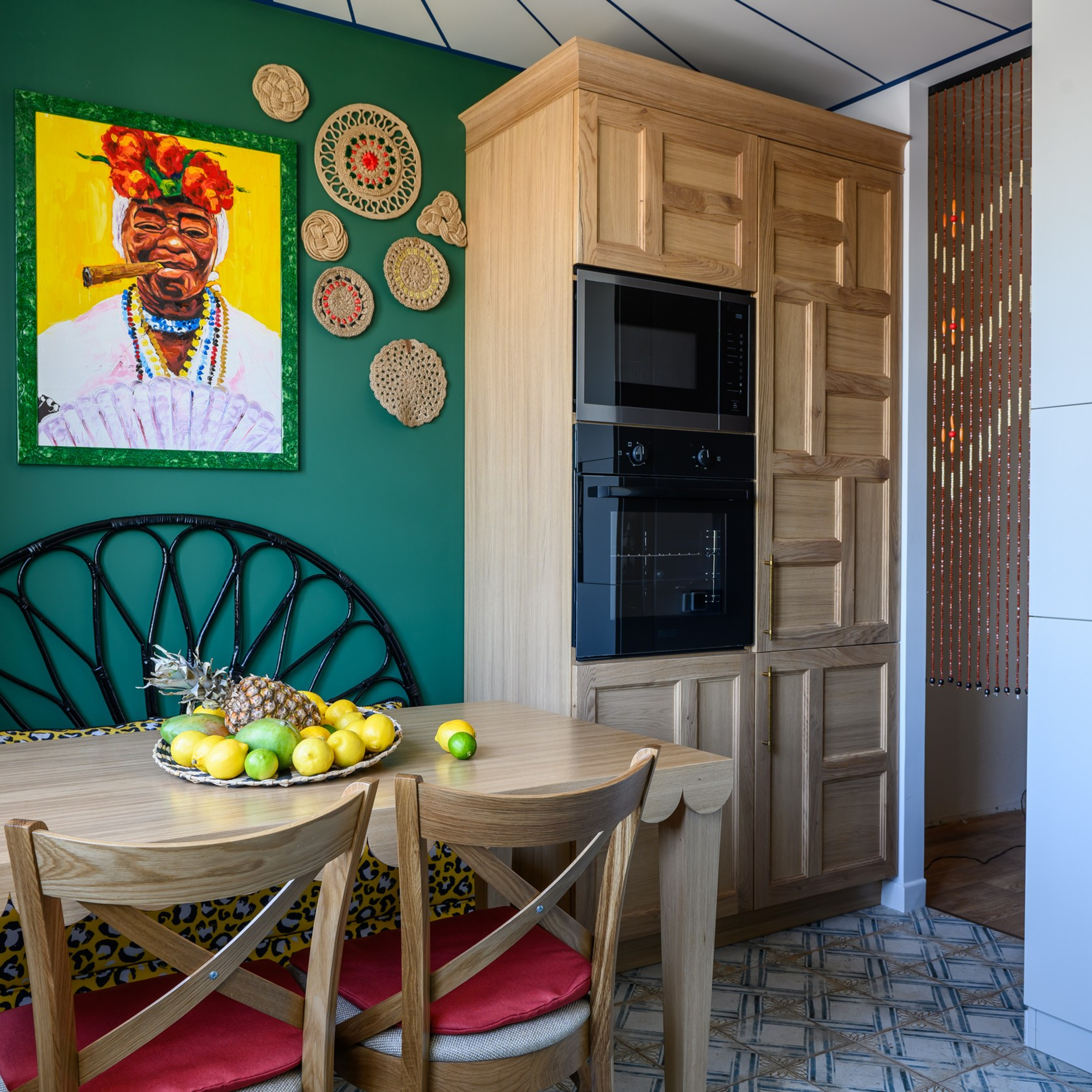 У входа собрали ответную часть кухни. Это два высоких пенала в шпоне дуба, соединенные классической «короной» из дубового массива. Шпонированные фасады – распашные, с изящными филенками, – все по эскизам Виолетты Долговой. Правую секцию дизайнер отдала под холодный цех, левую – под горячий. 