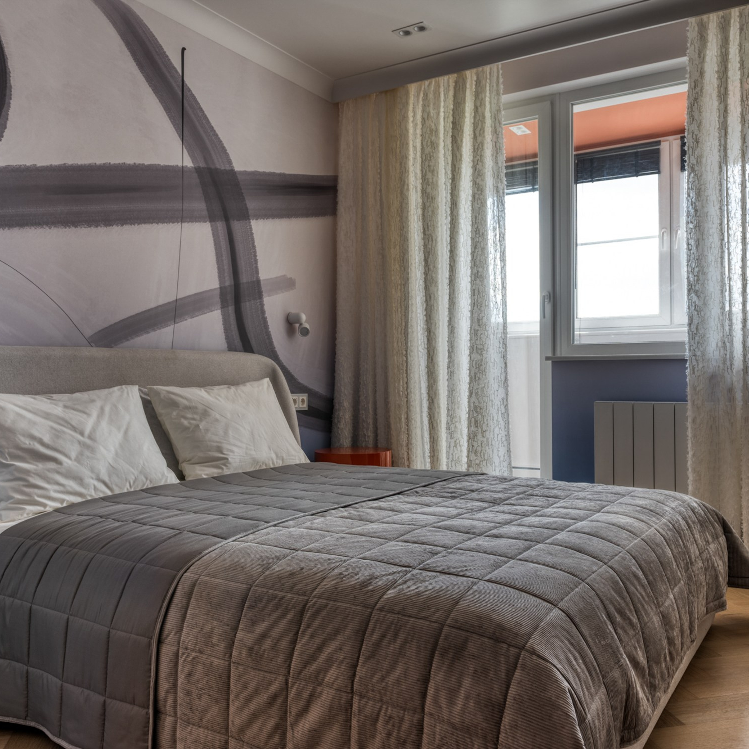 В такой комнате хочется жить. Постель застелили стеганым пледом и белоснежным бельем. Кроме того, автор проекта позаботилась о комфорте.