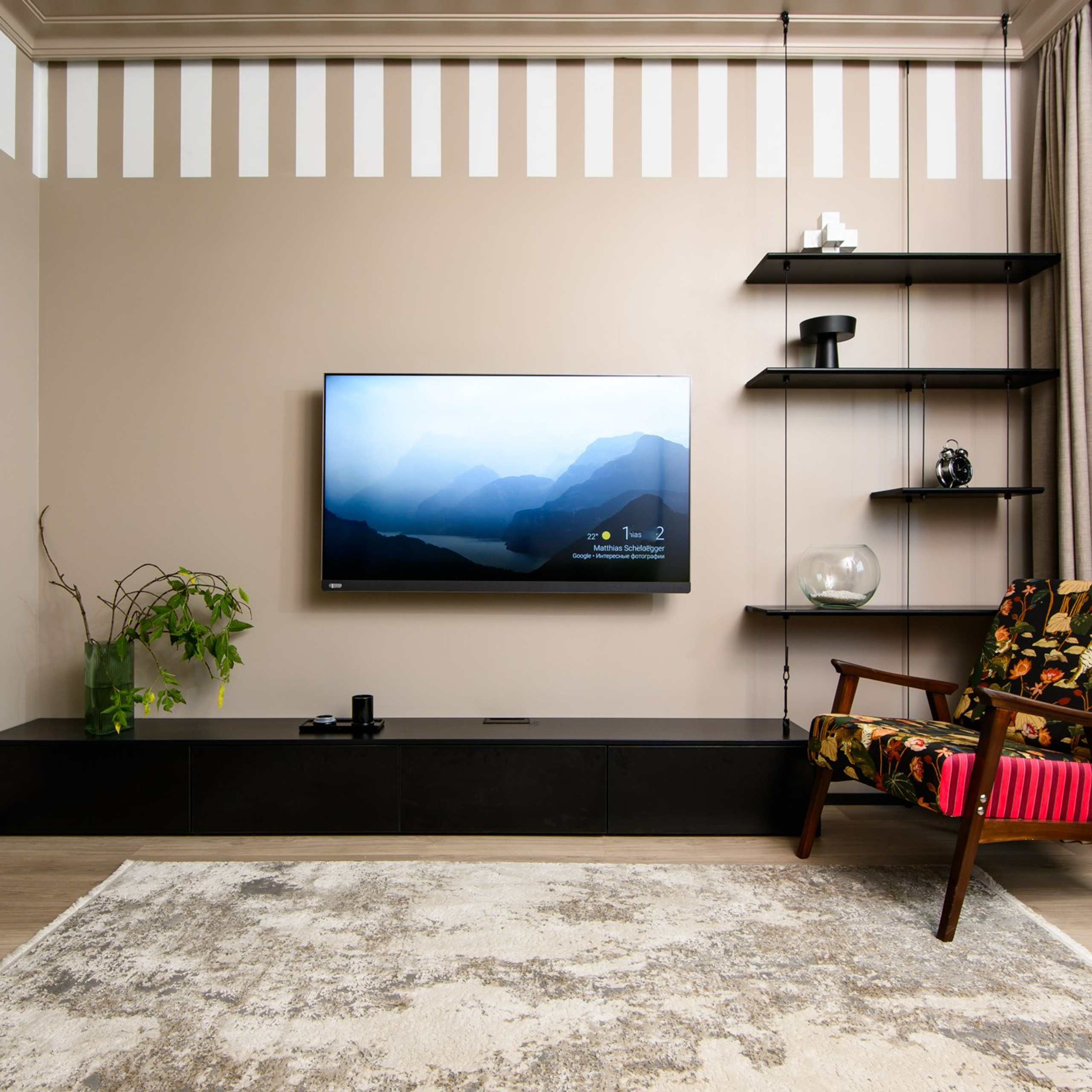 Длинная подвесная консоль с выдвижными ящиками выполнена из ЛДСП коллекции Time. Рядом с консолью как часть единой конструкции собрали стеллаж. К полу и потолку прикрутили кольца-держатели. В них закрепили стальные тросы, и одну за другой нанизали полки разного размера. После чего одним концом троса стеллаж «пришвартовали» к консоли.