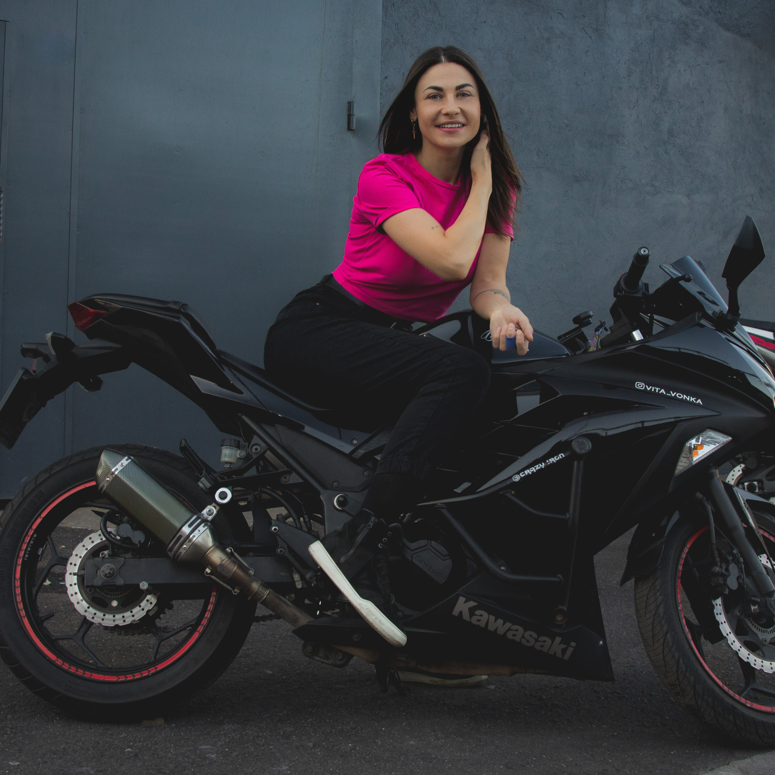 Контрастное фото женщины на мотоцикле в розовой футболке