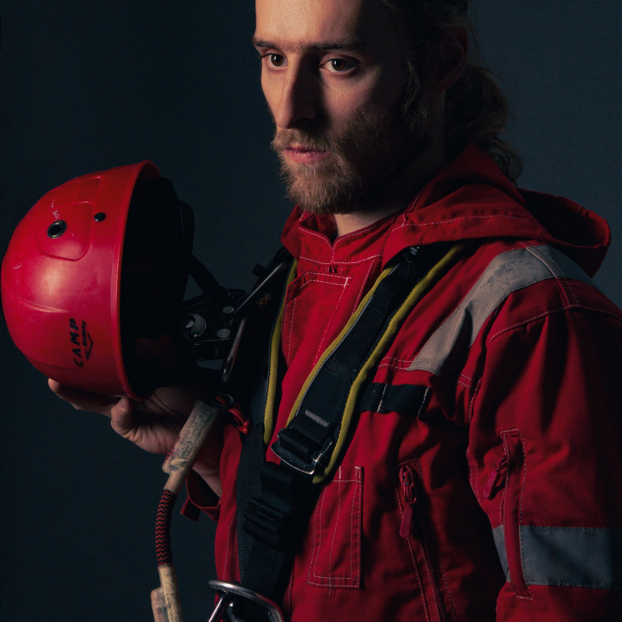 Фото мужчины строителя-альпиниста с каской в руках