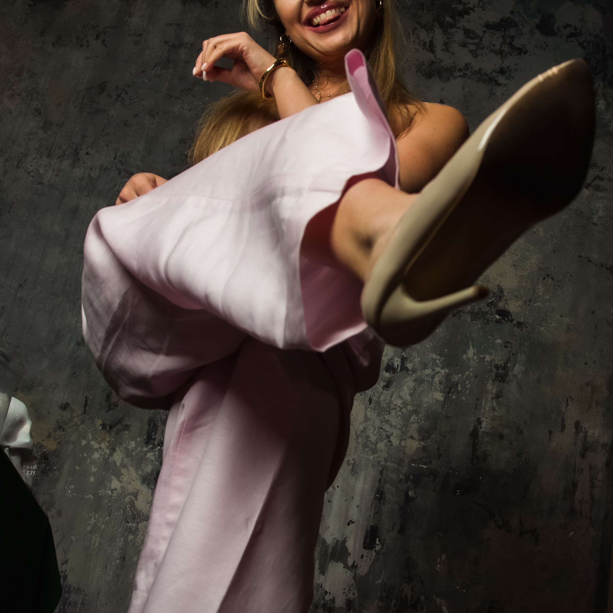 Фото веселой женщины в костюме и задравшей ногу