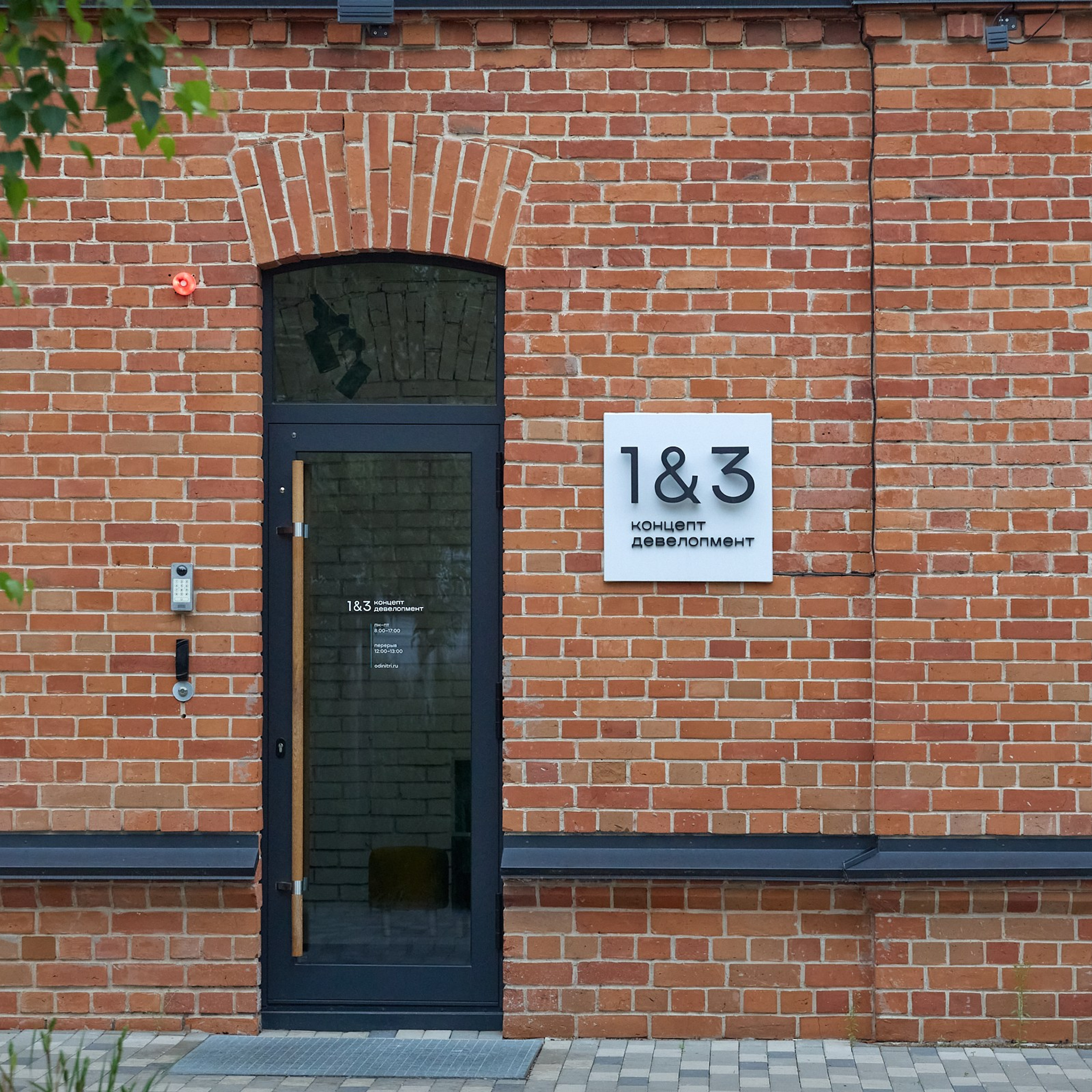 Черная стеклянная дверь в кирпичной стене. Детальная съемка кирпичного фасада с декоративной кладкой.