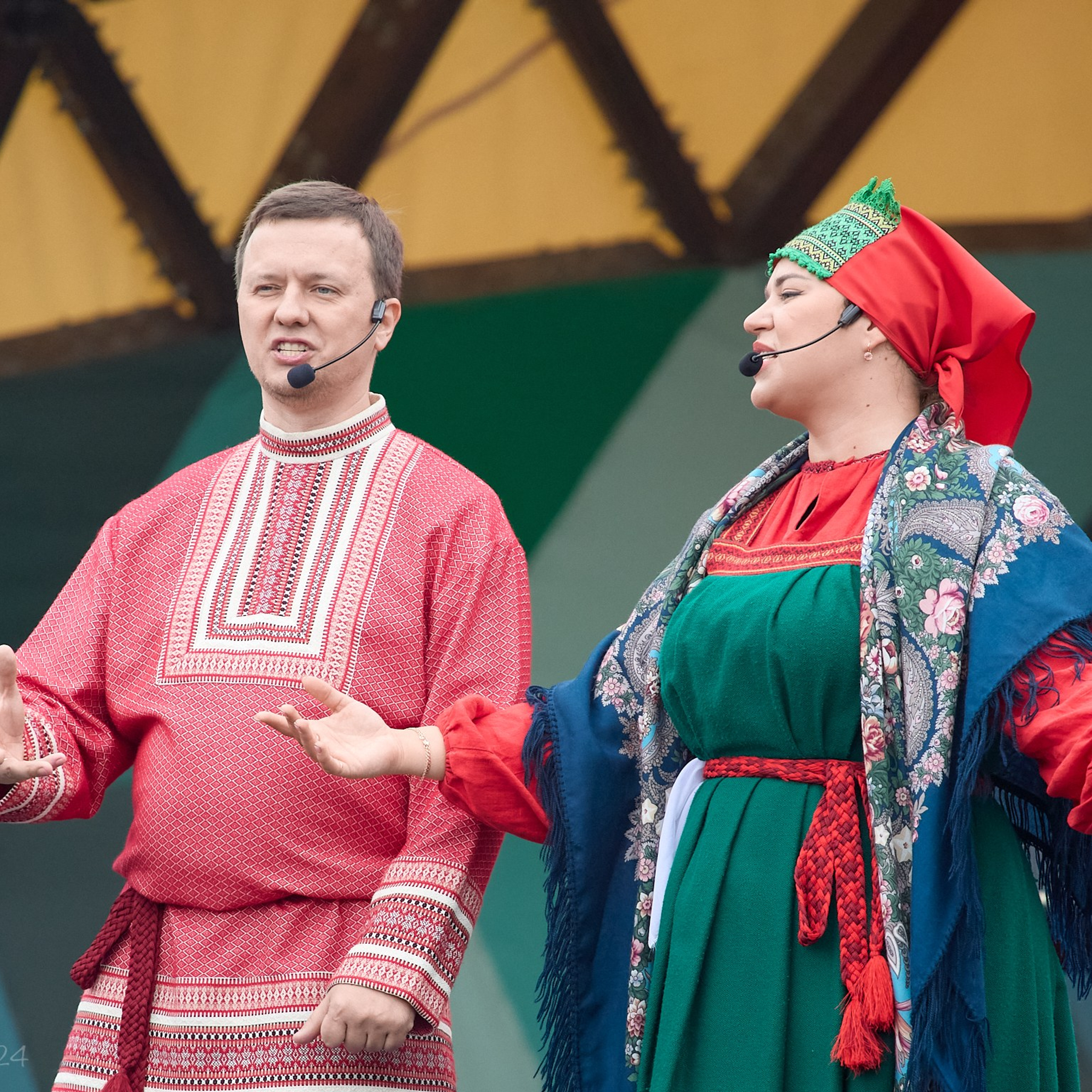 Артисты в  русских народных костюмах поют на сцене.