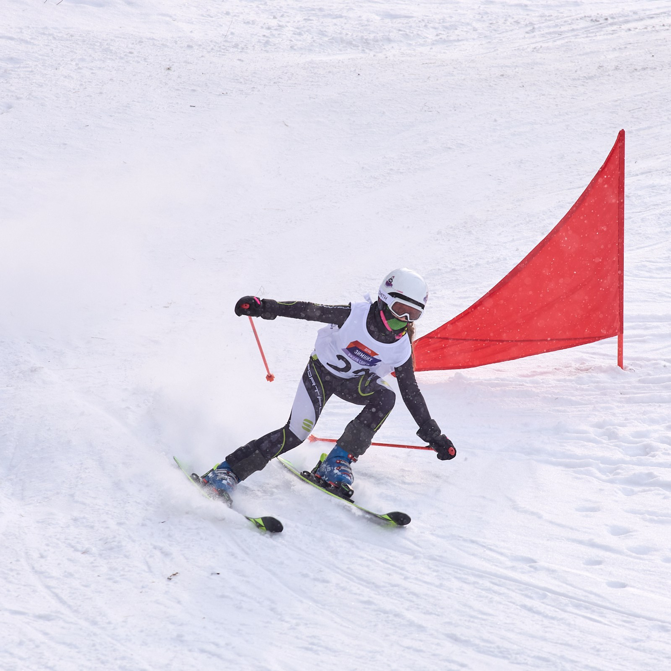 Юная лыжница обходит препятствие.