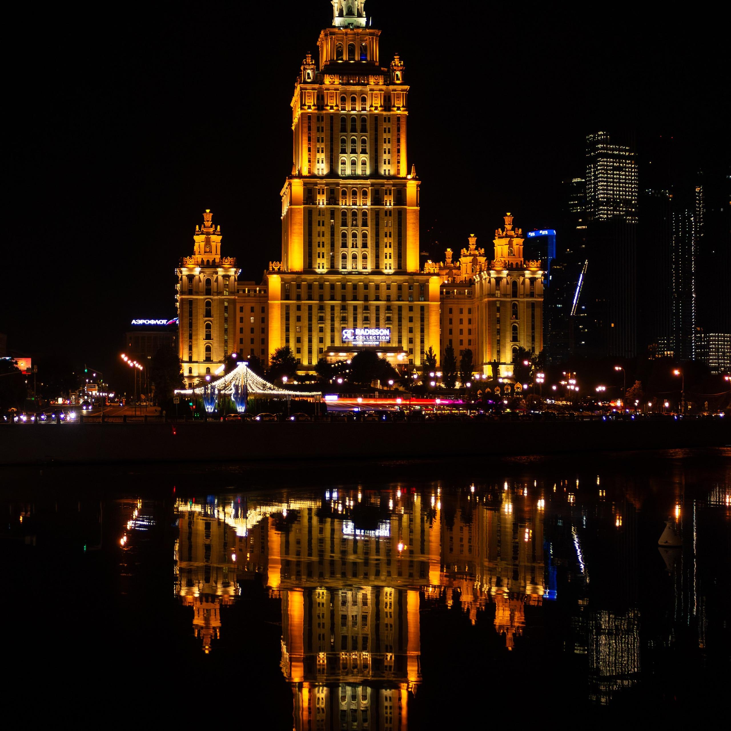 Ночной вид на подсвеченное здание гостиницы «Украина» с отражением в Москва-реке. Архитектурная съёмка. 