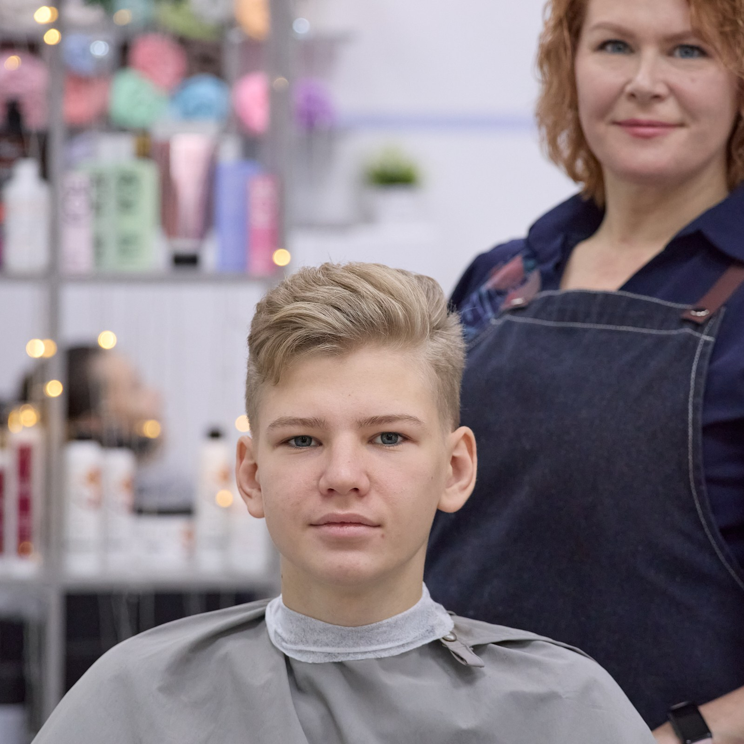 Клиент и мастер-парикмахер смотрят в камеру.