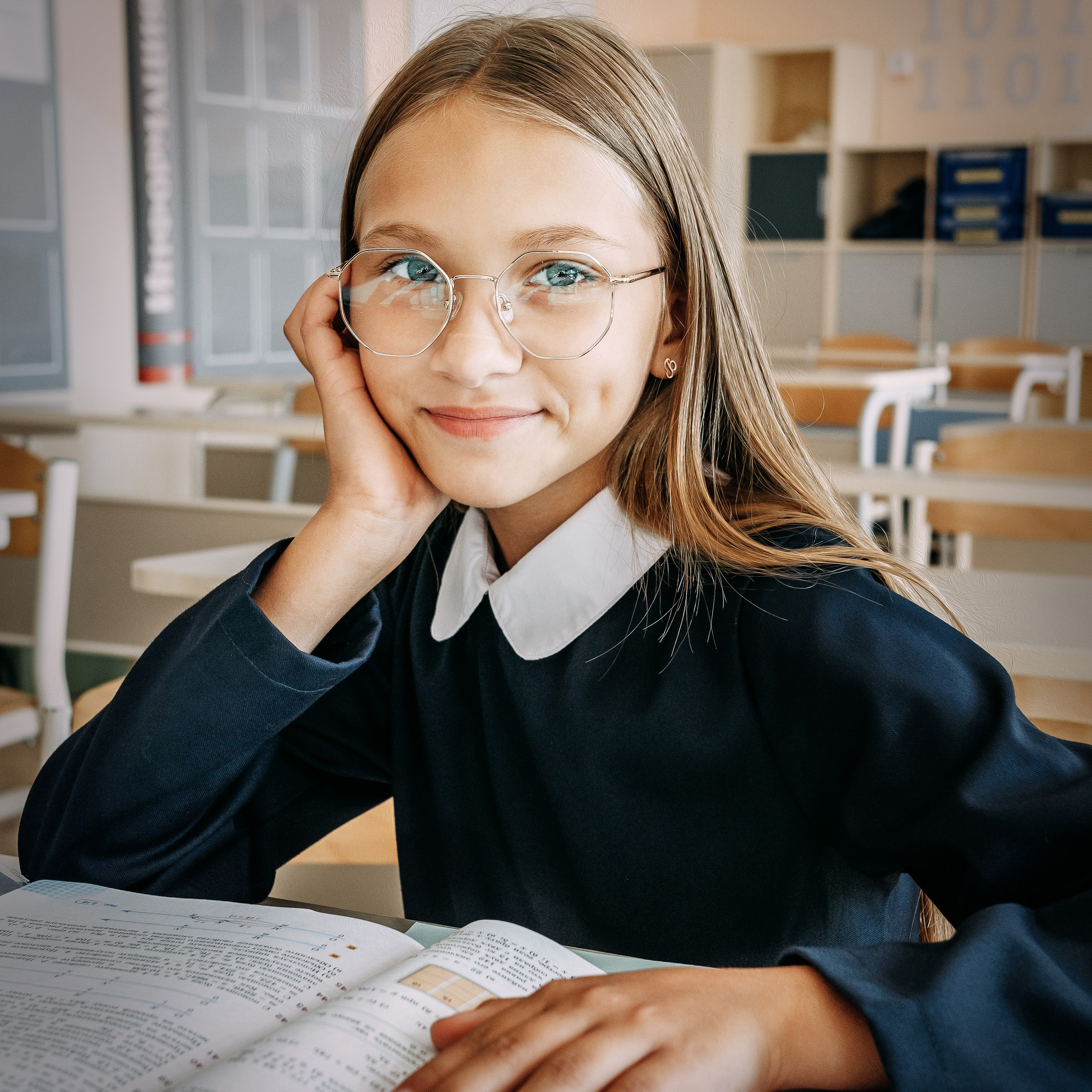 Портрет ученицы школы в очках вместе с книгами. 