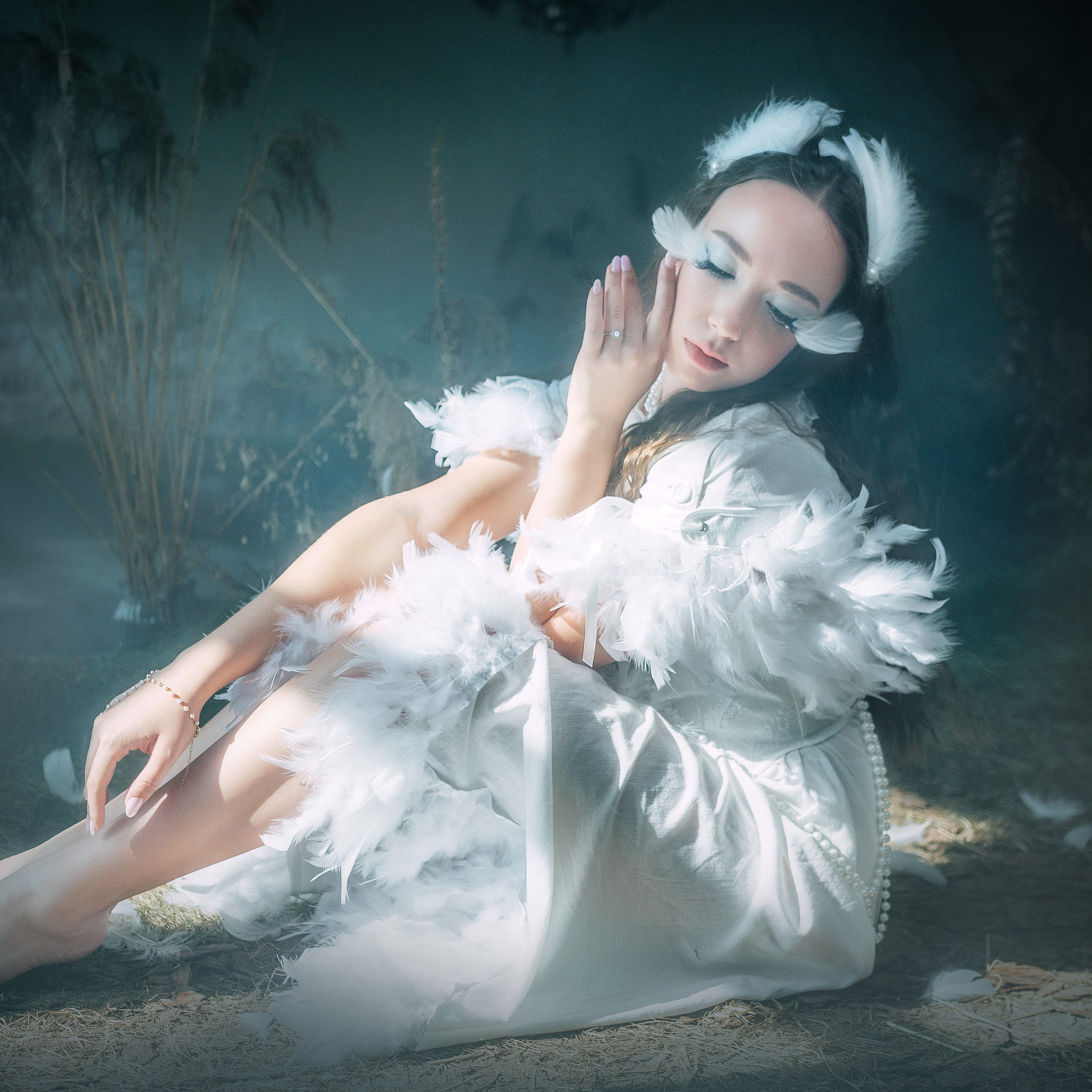 Фотосессия девушки лебеди. Девушка одета в белые перья и жемчуга. Макияж с перьями.