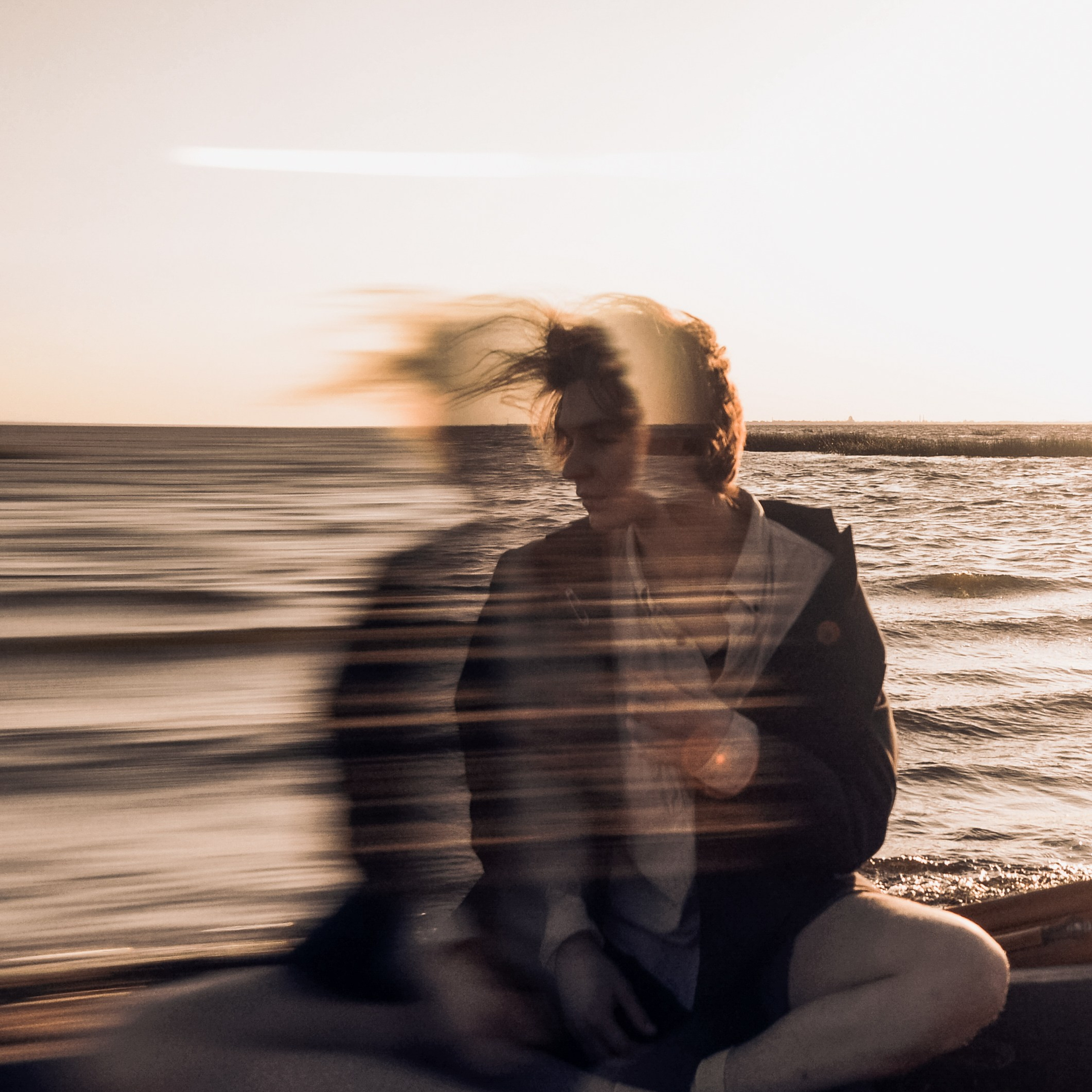 фотосессия парня на закате у воды художественный смаз