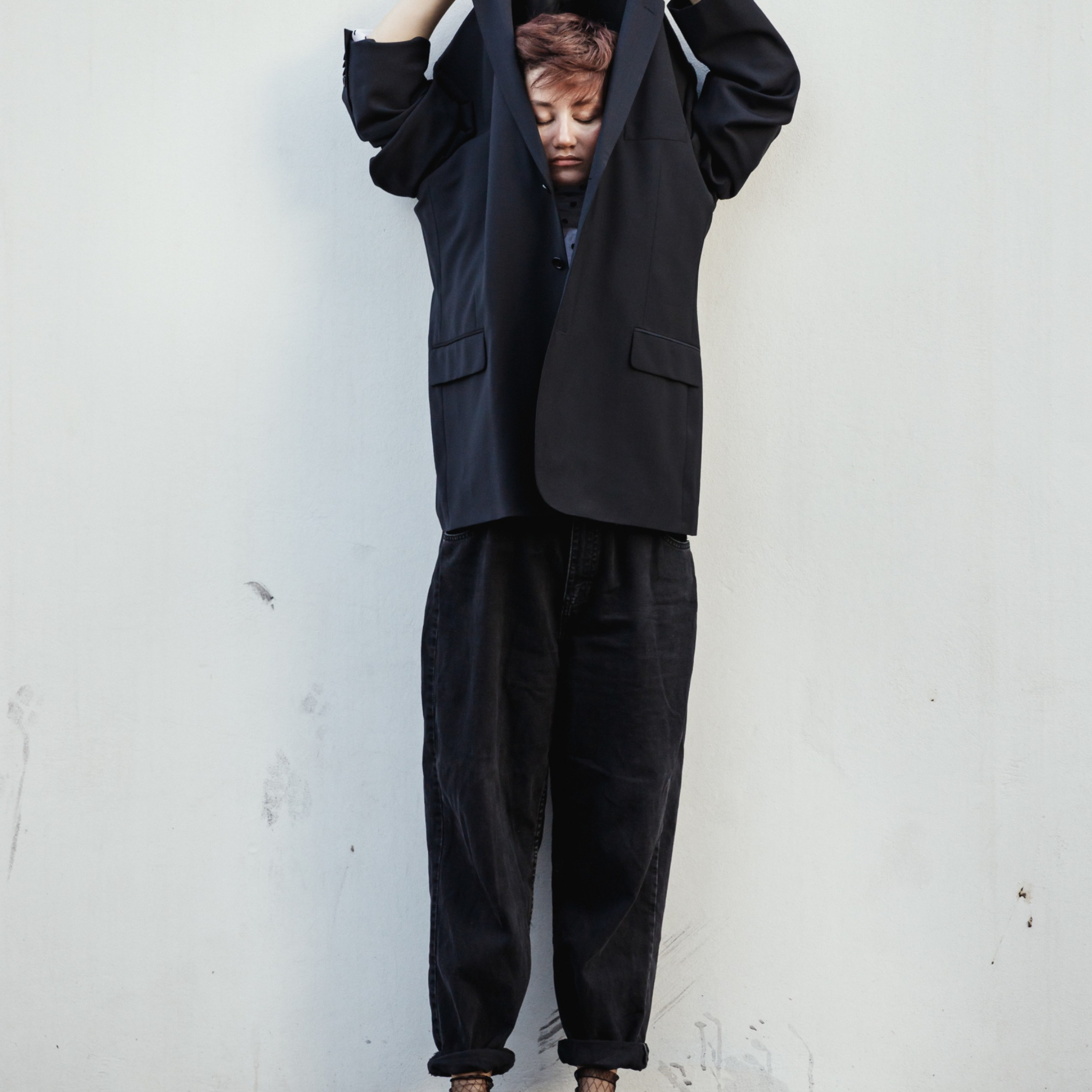 Модель стоит в креативной позе в костюме