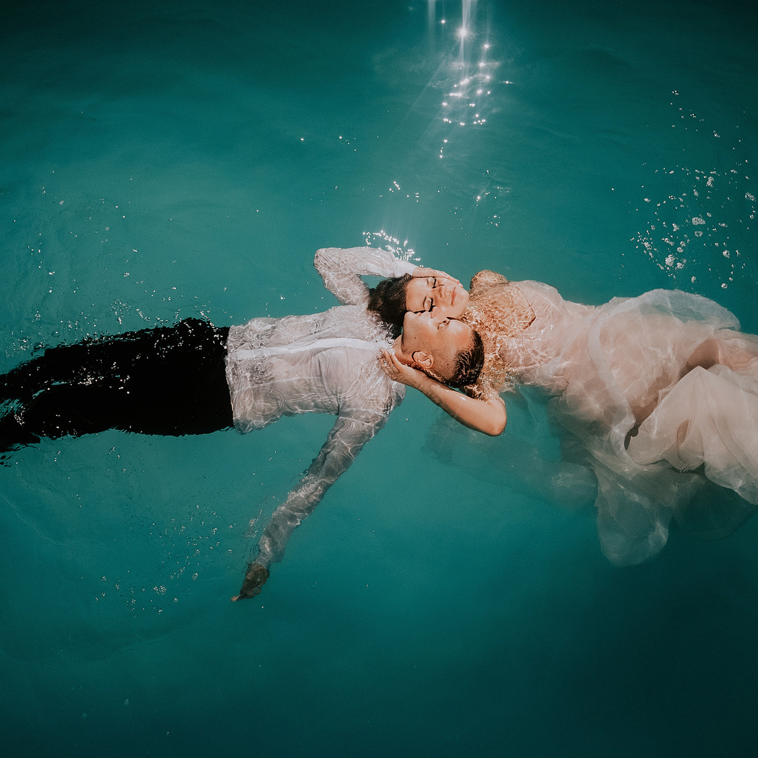 Жених и невеста в конце свадебного дня прыгнули в бассейн.