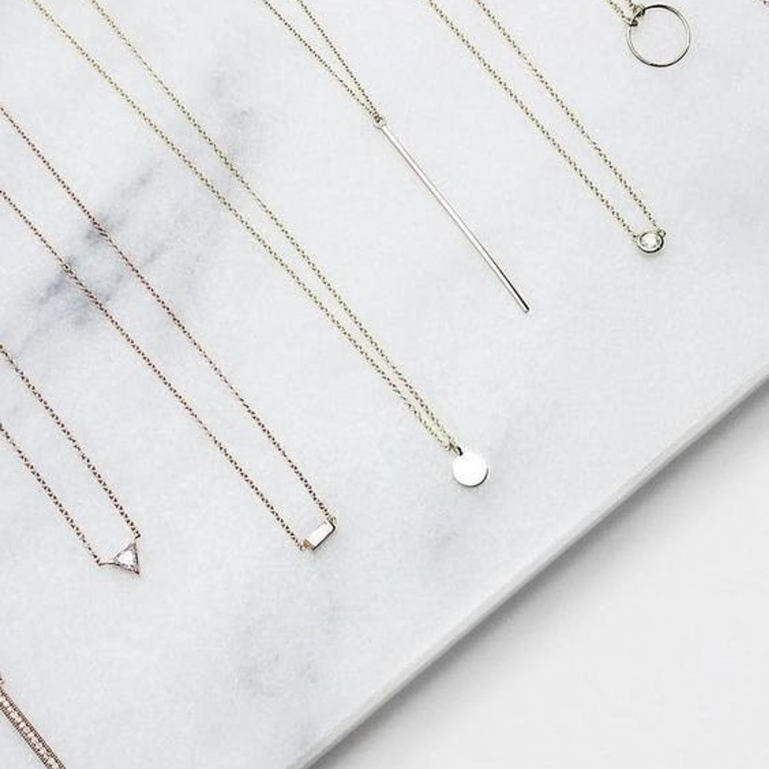 Предметная съемка бижутерии на белом фоне, акцент на минимализме и стиле