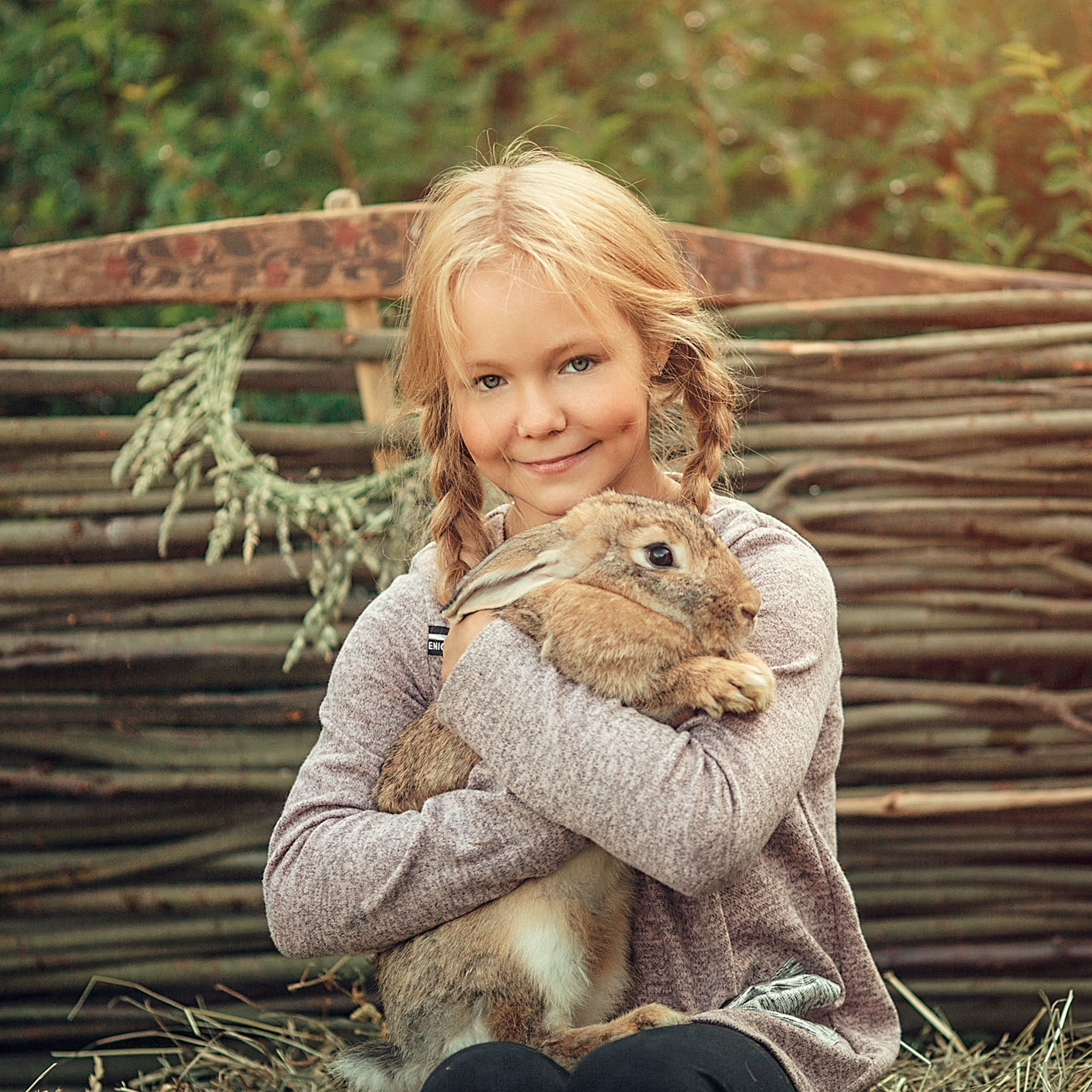 Портрет девочки со светлыми волосами обнимает кролика