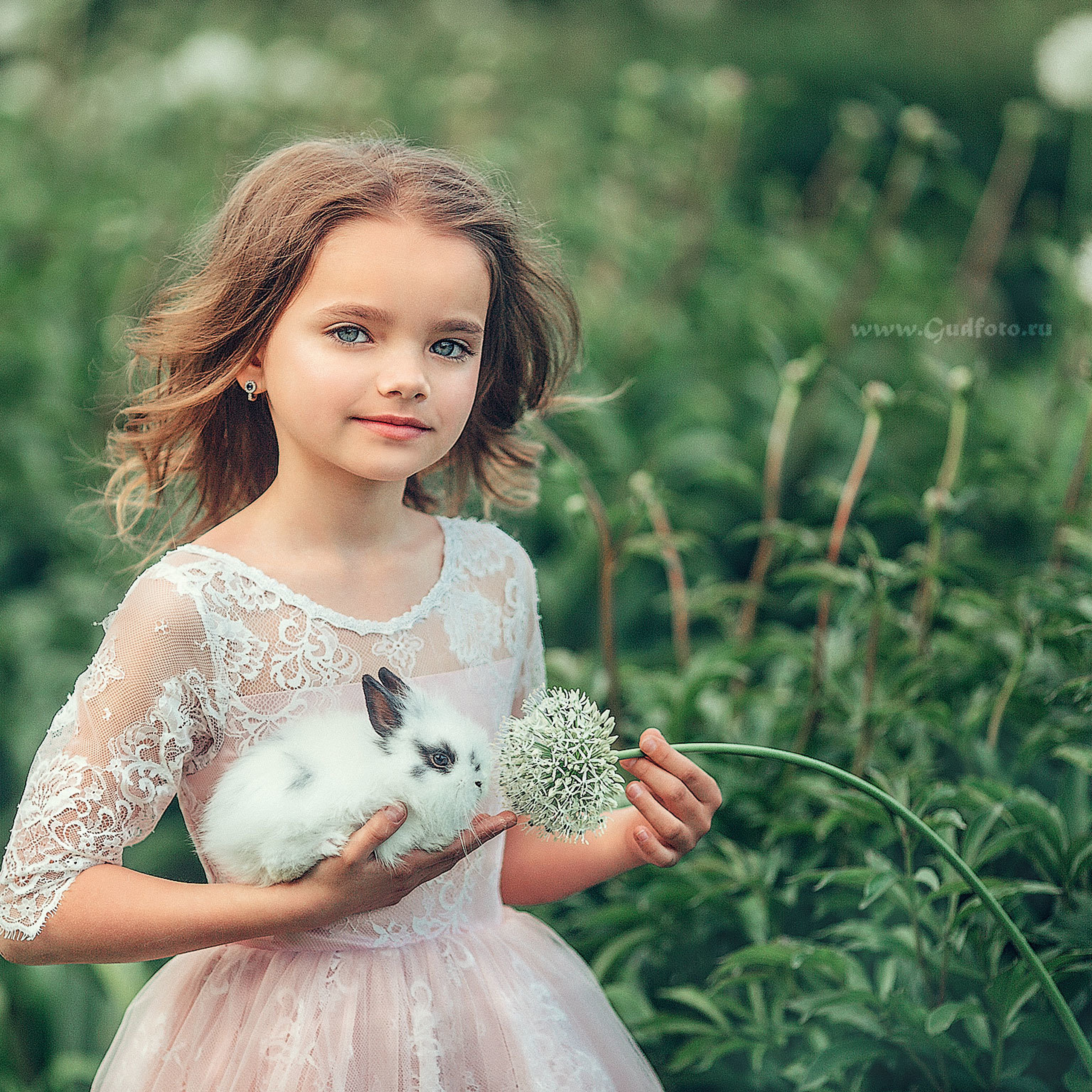 Девочка брюнетка с белым кроликом в парке на природе летом