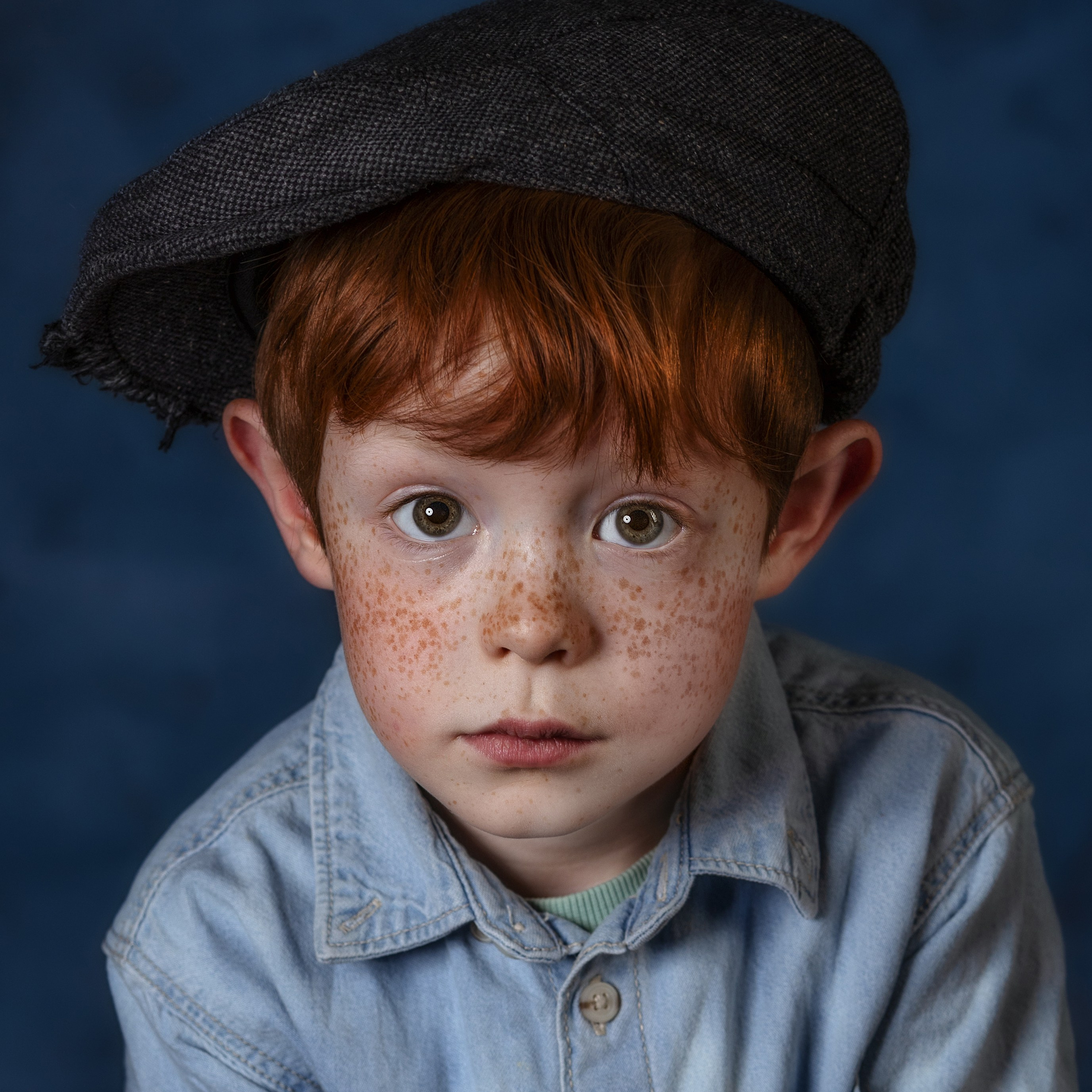 Портрет рыжеволосого мальчика с веснушками в кепке