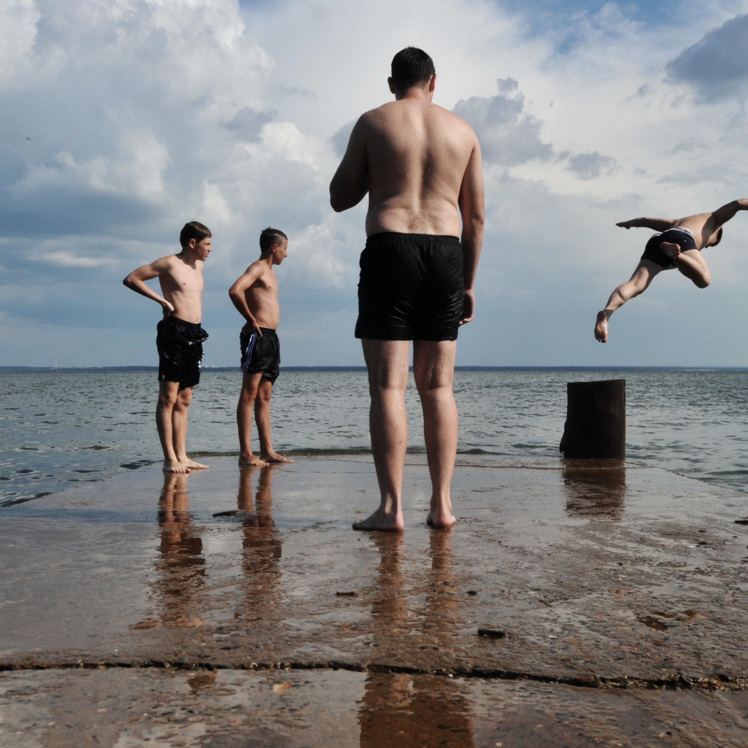 Россия. Новосибирская область. 5 июля 2014 года. Молодые люди на волнорезе.