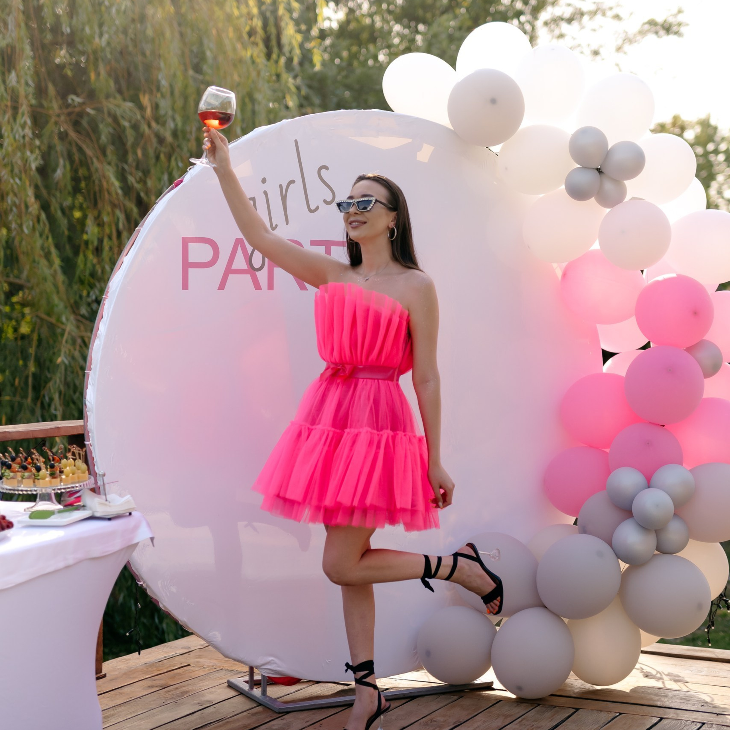 Гости девичника фотографируются у тематической фотозоны с шарами