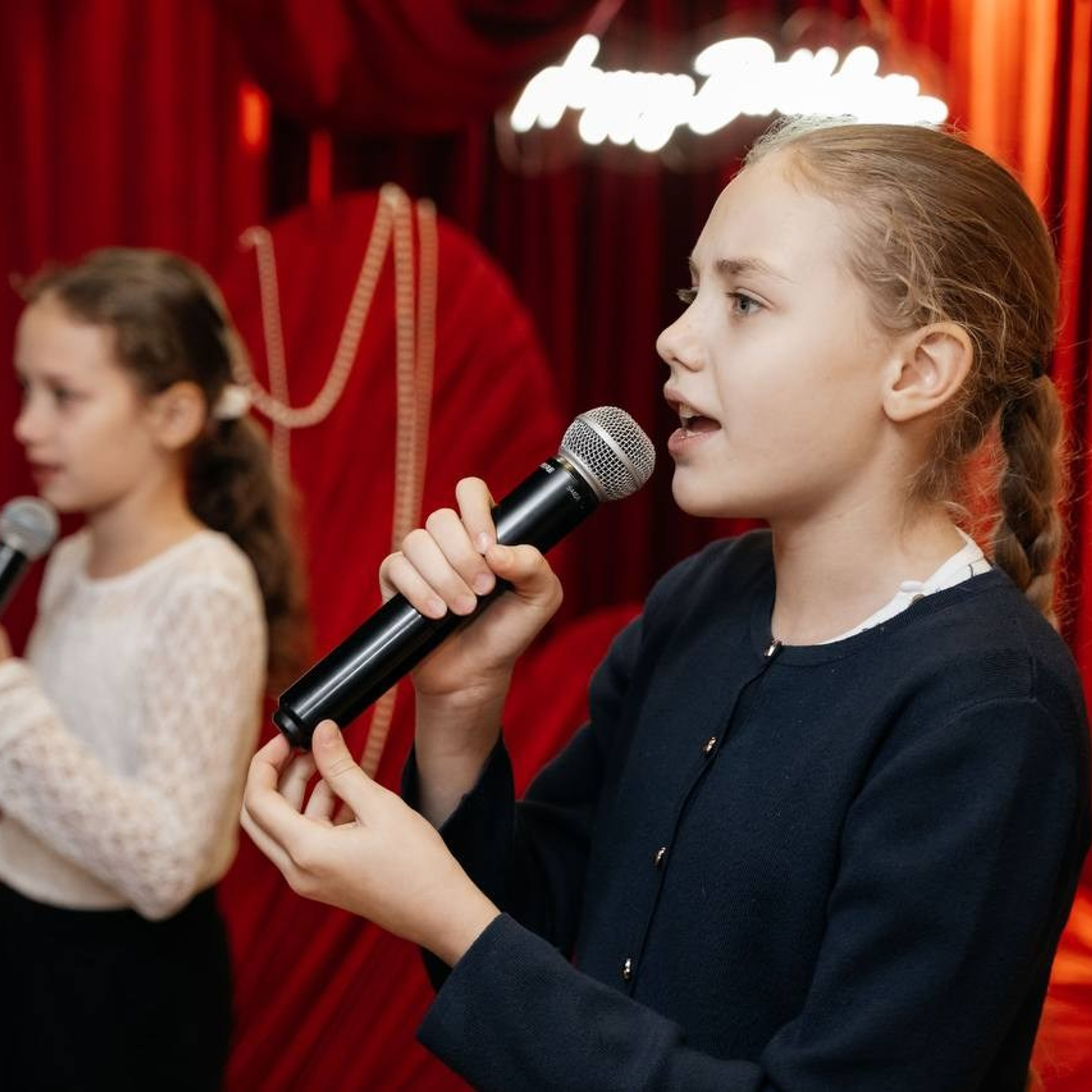 Дети поют на красном дне рождения в Ростов-на-Дону, создавая праздничную и веселую атмосферу.