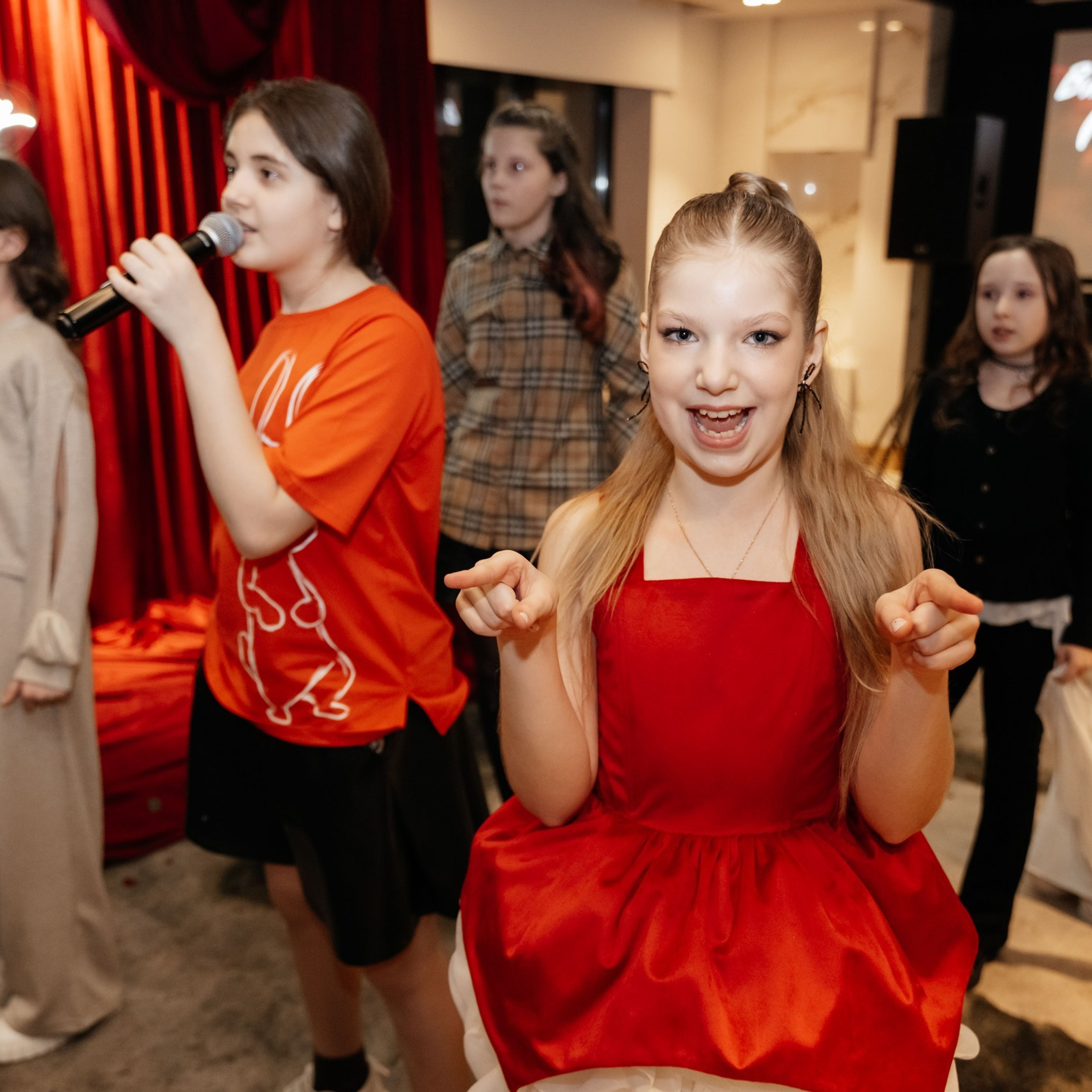 Дети поют на красном дне рождения в Ростов-на-Дону, создавая праздничную и веселую атмосферу.