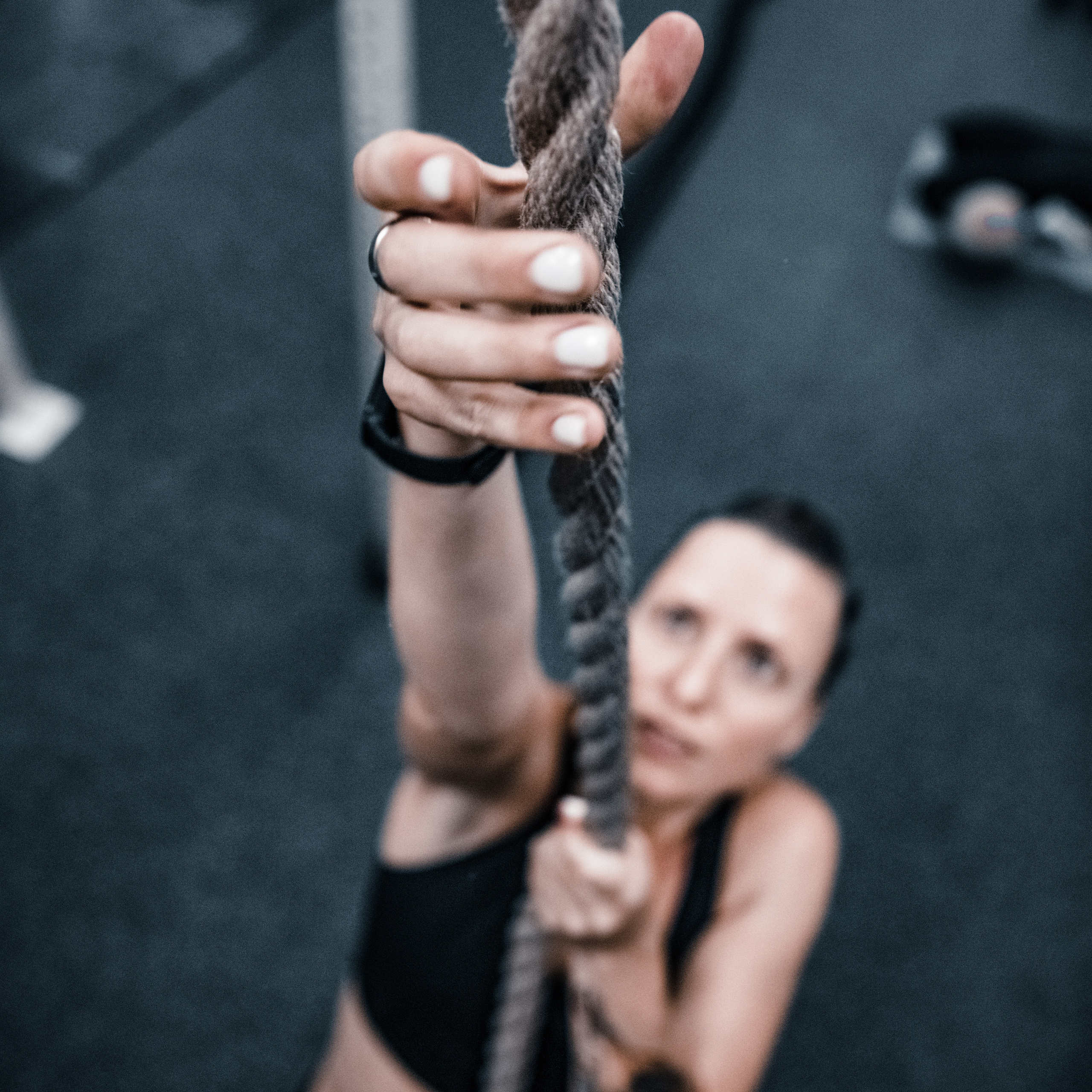 девушка взбирается по канату вверх