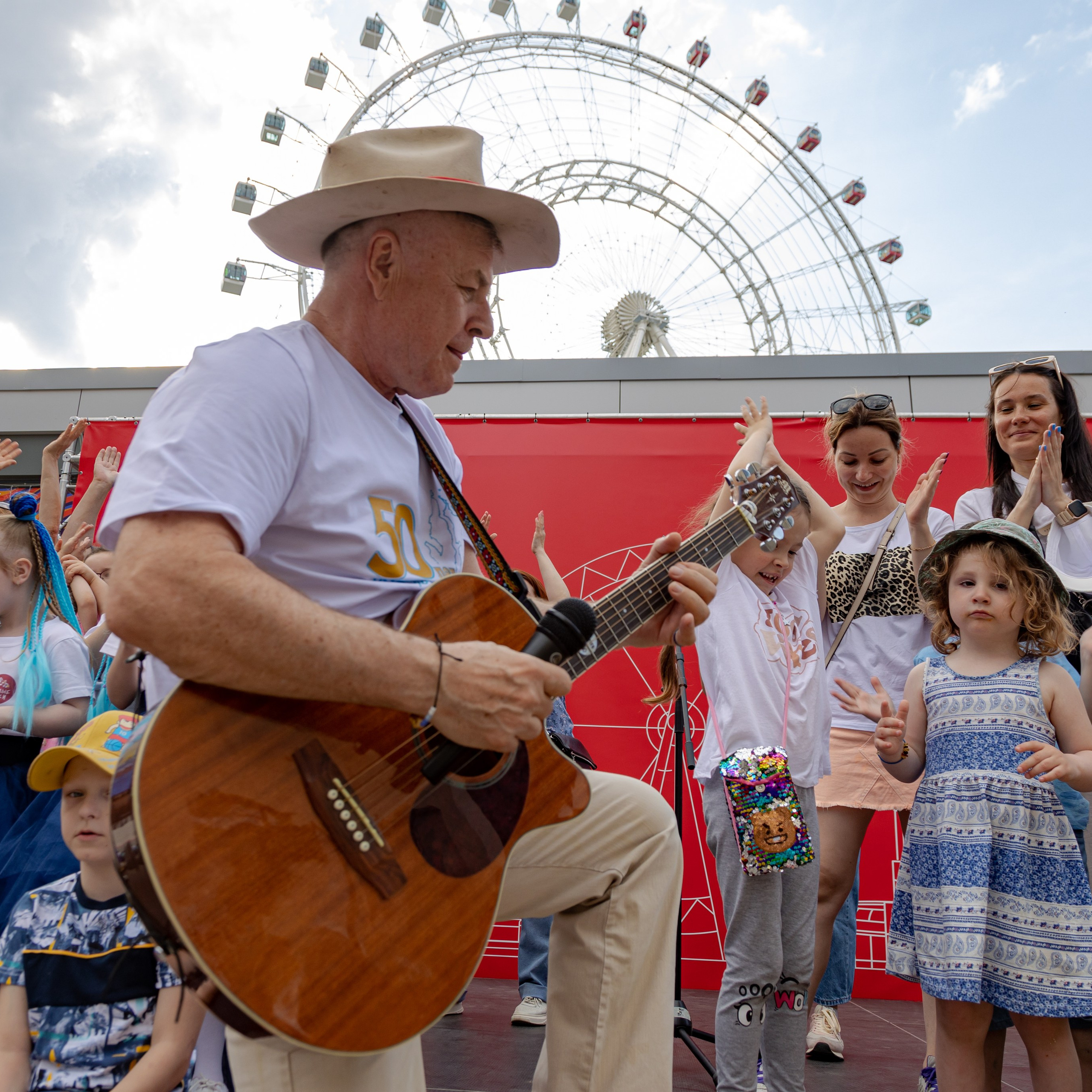 Григорий Гладков на концертной площадке выступает перед детьми