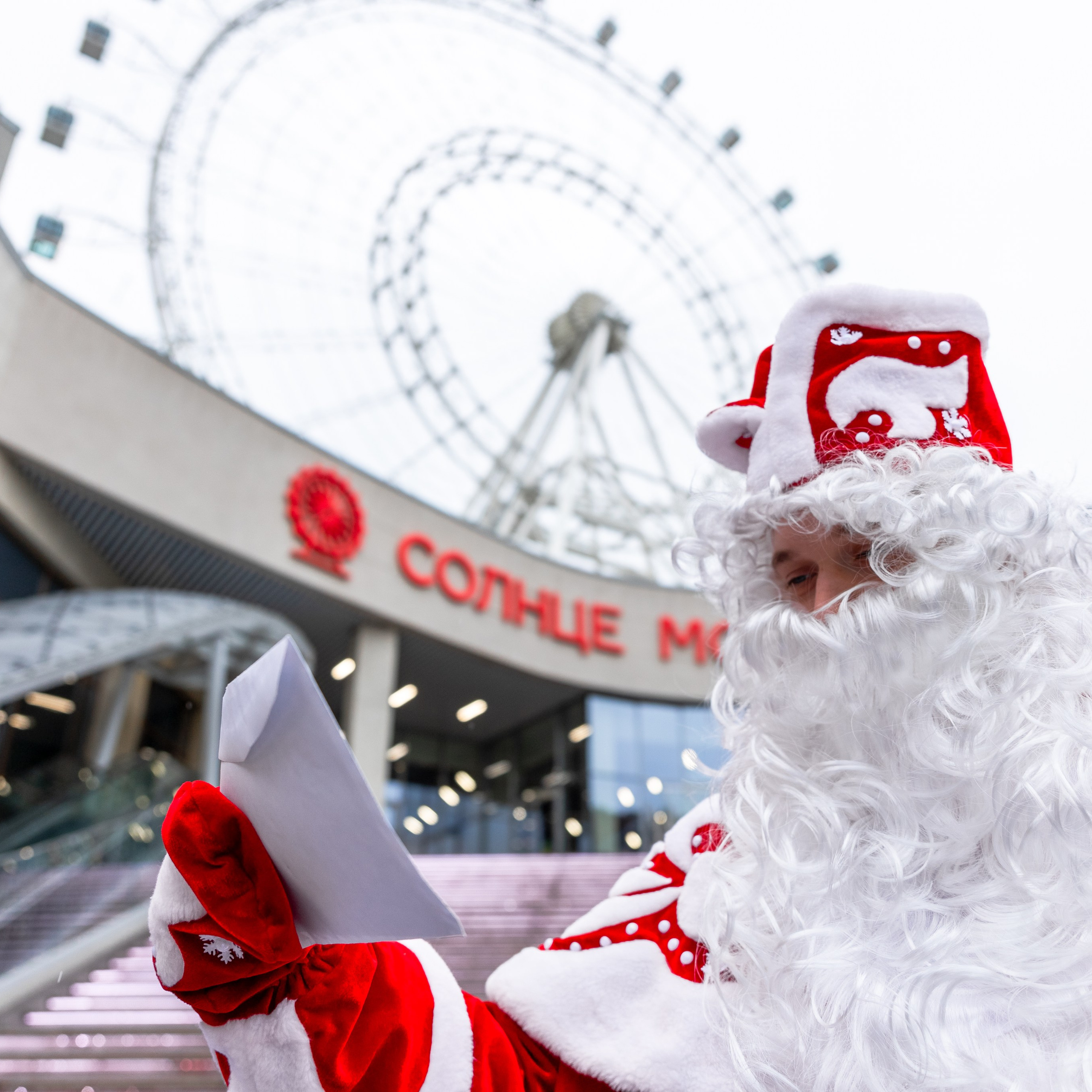 Дед Мороз на фоне колеса обозрения 