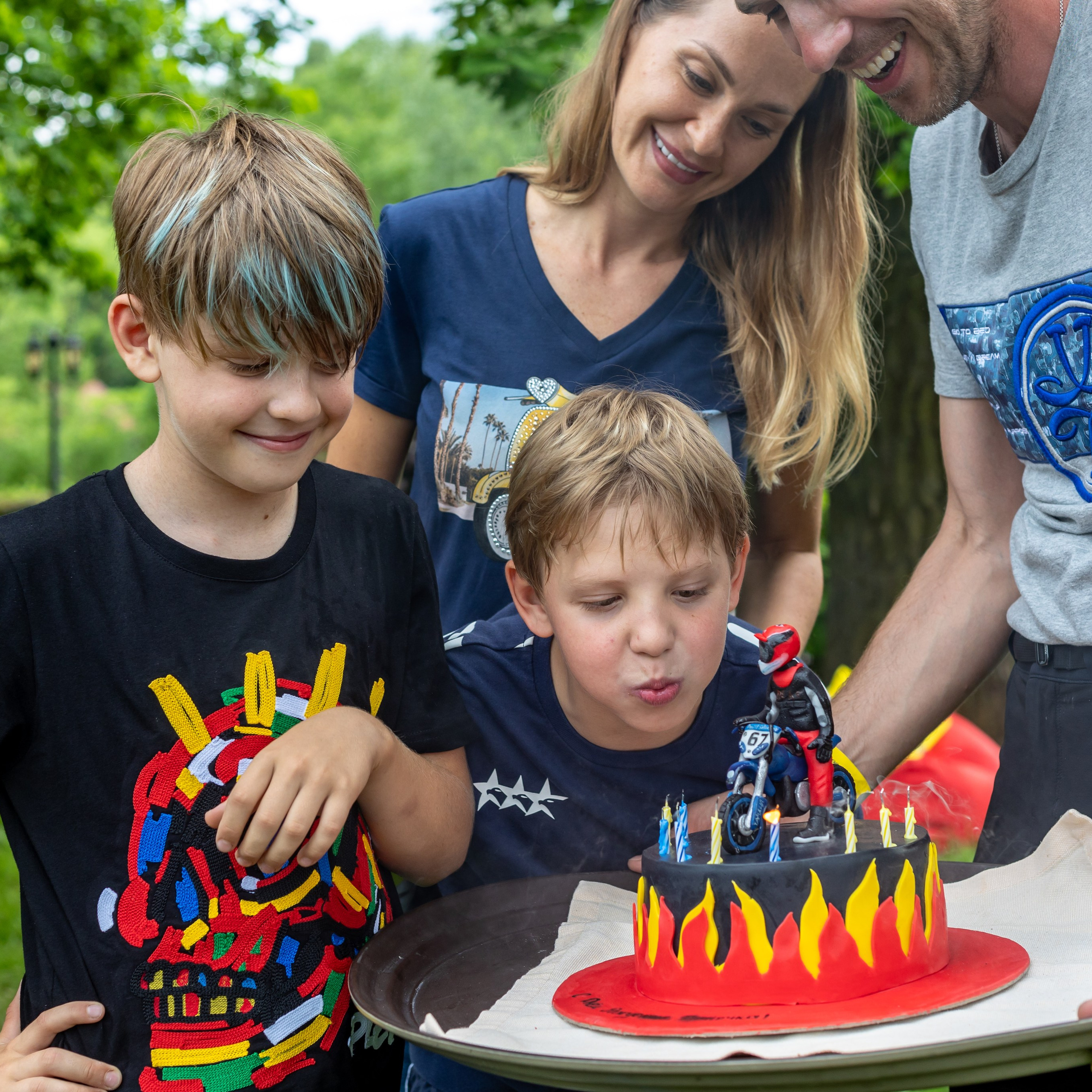Молодая семья празднует детский день рождения с тортом на природе