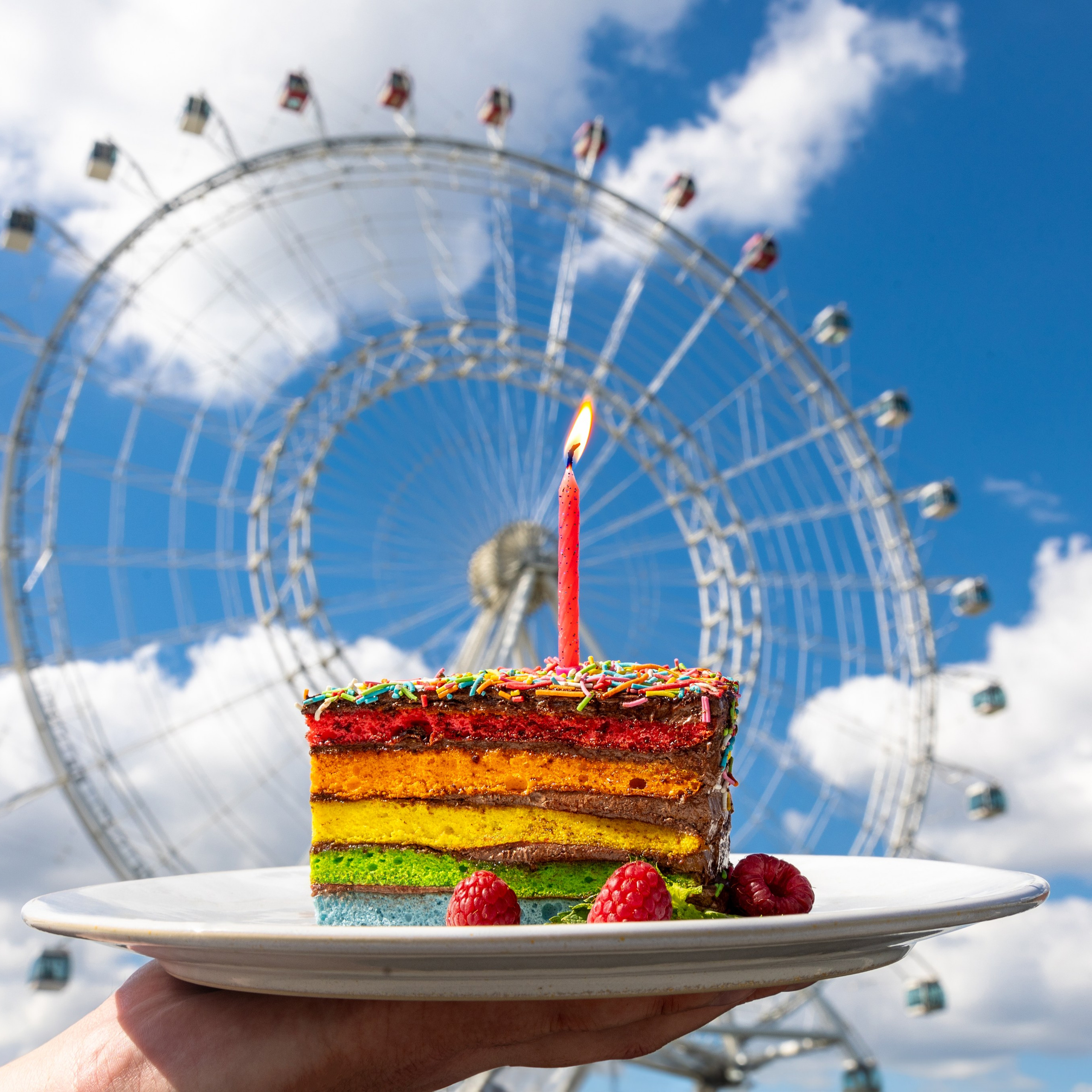 Разноцветный торт на фоне синего неба