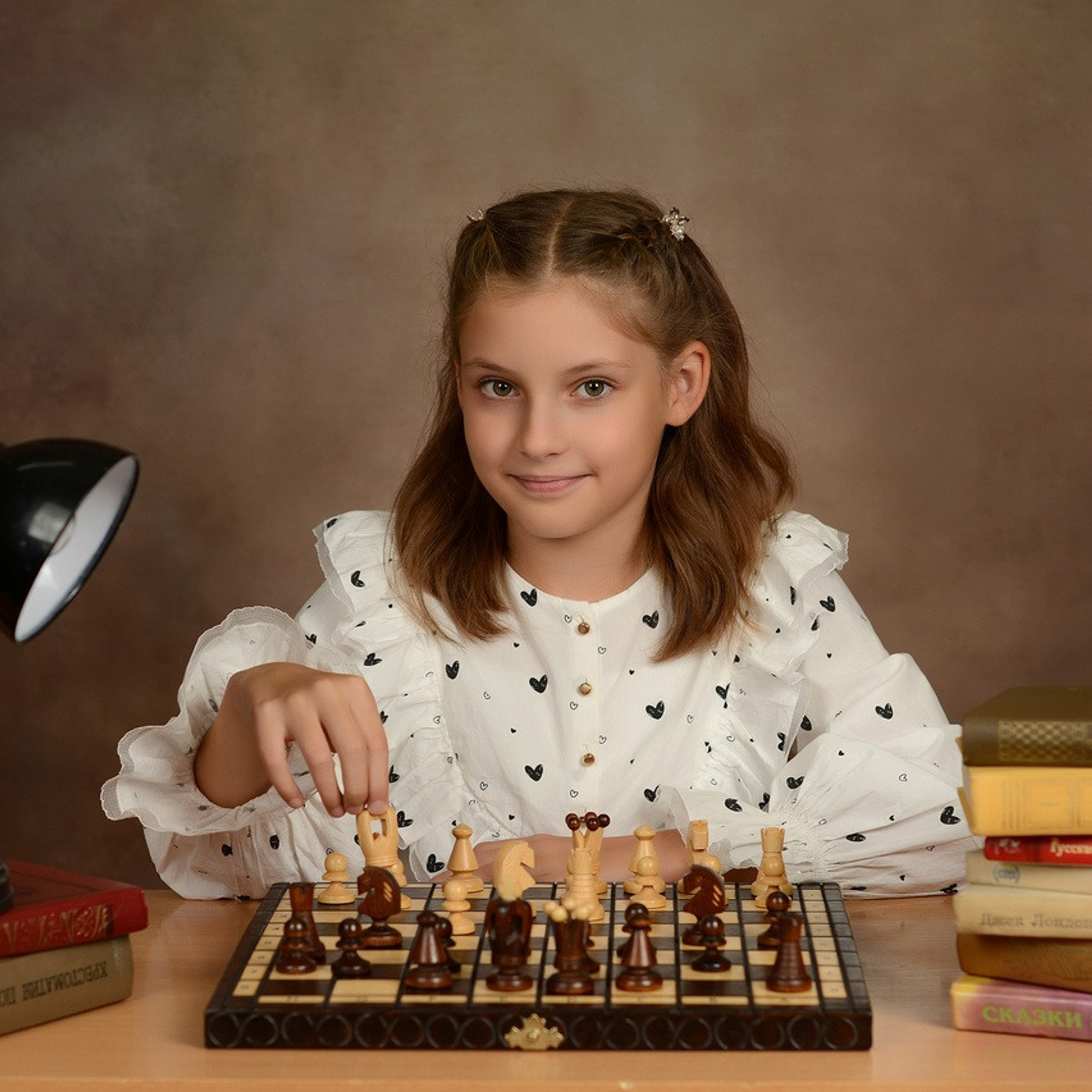 Фото красивой четвероклашки за игрой в шахматы