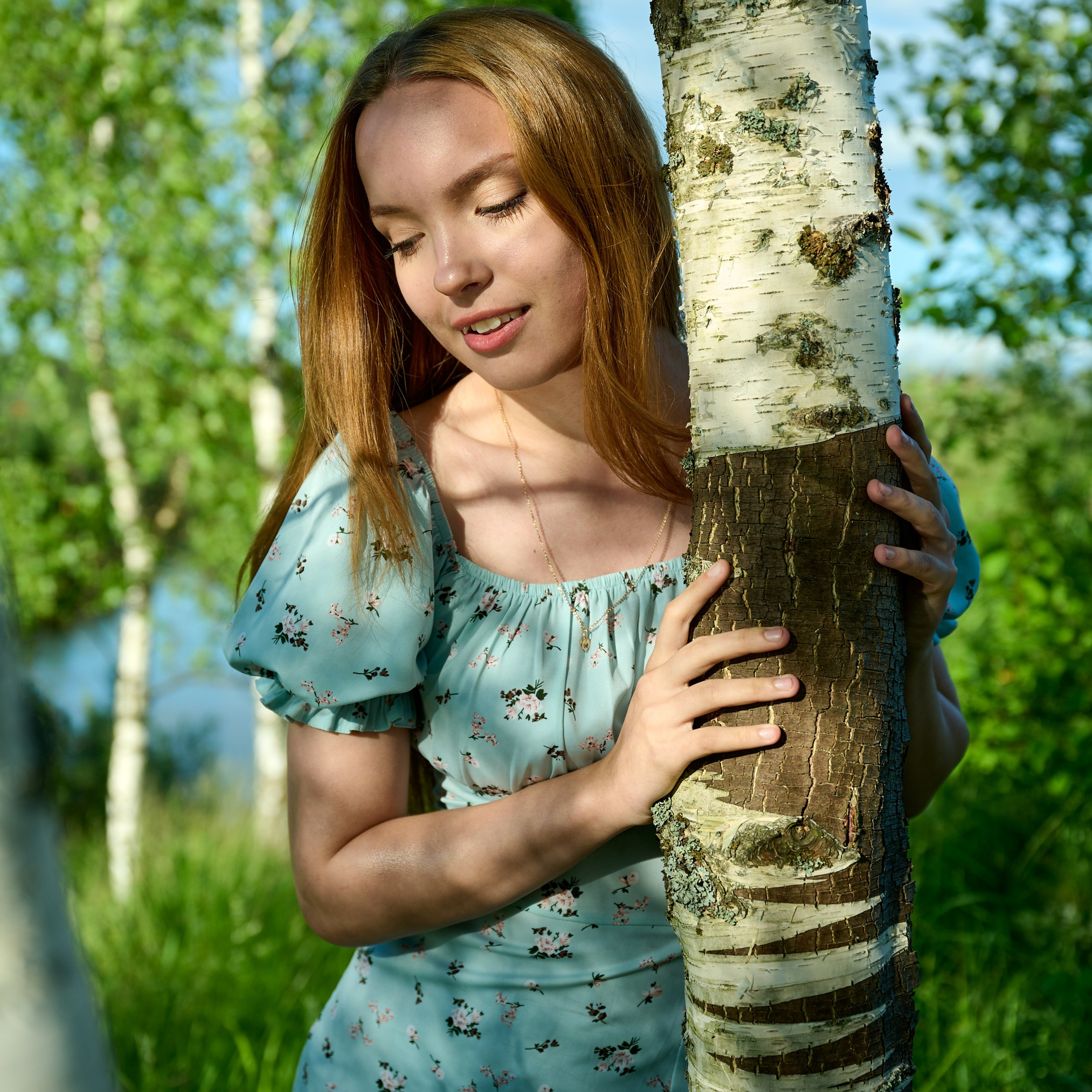 Стоит у ствола белой берёзы, глаза закрыты, лёгкое прикосновение к коре