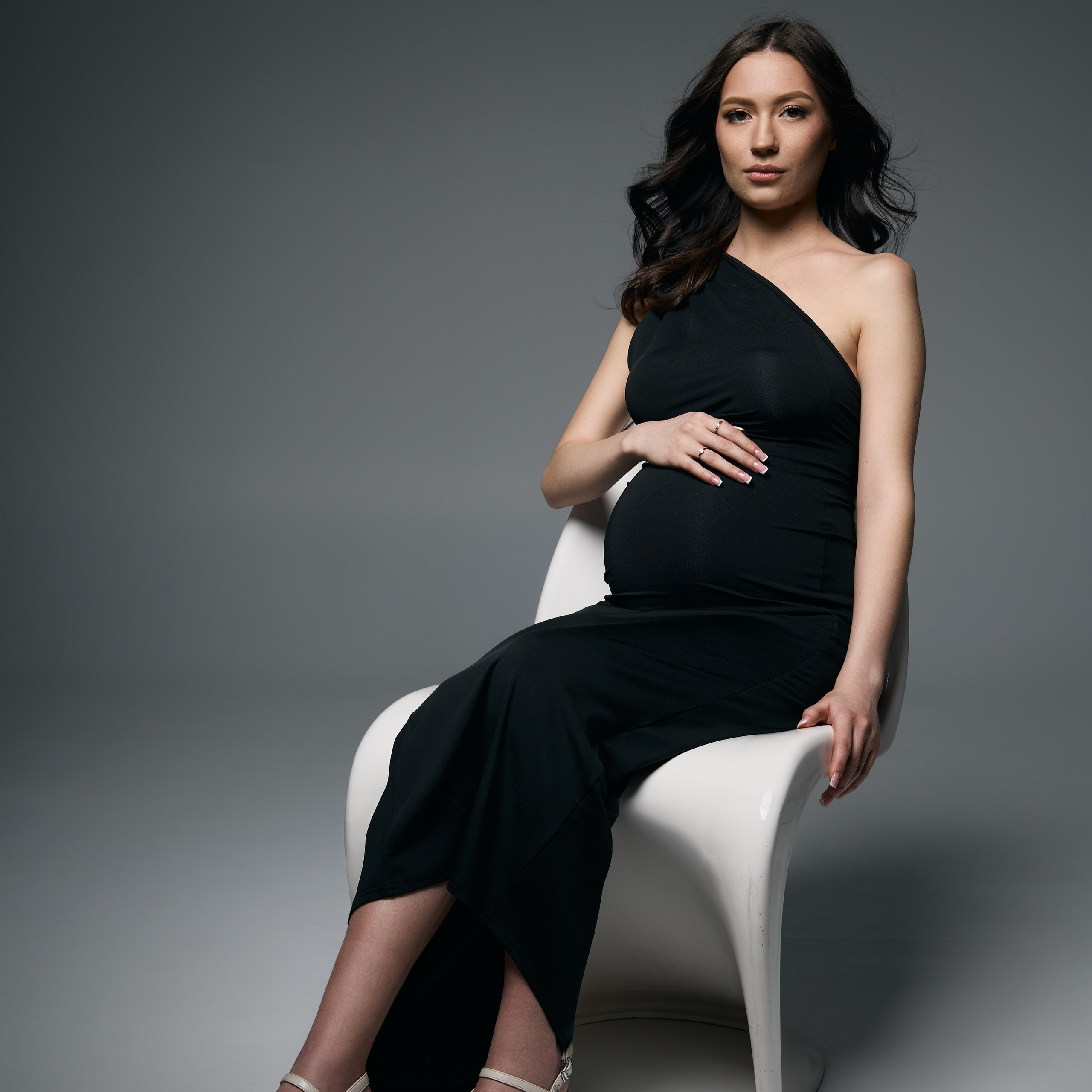 Студийная съемка беременности девушки в черном платье