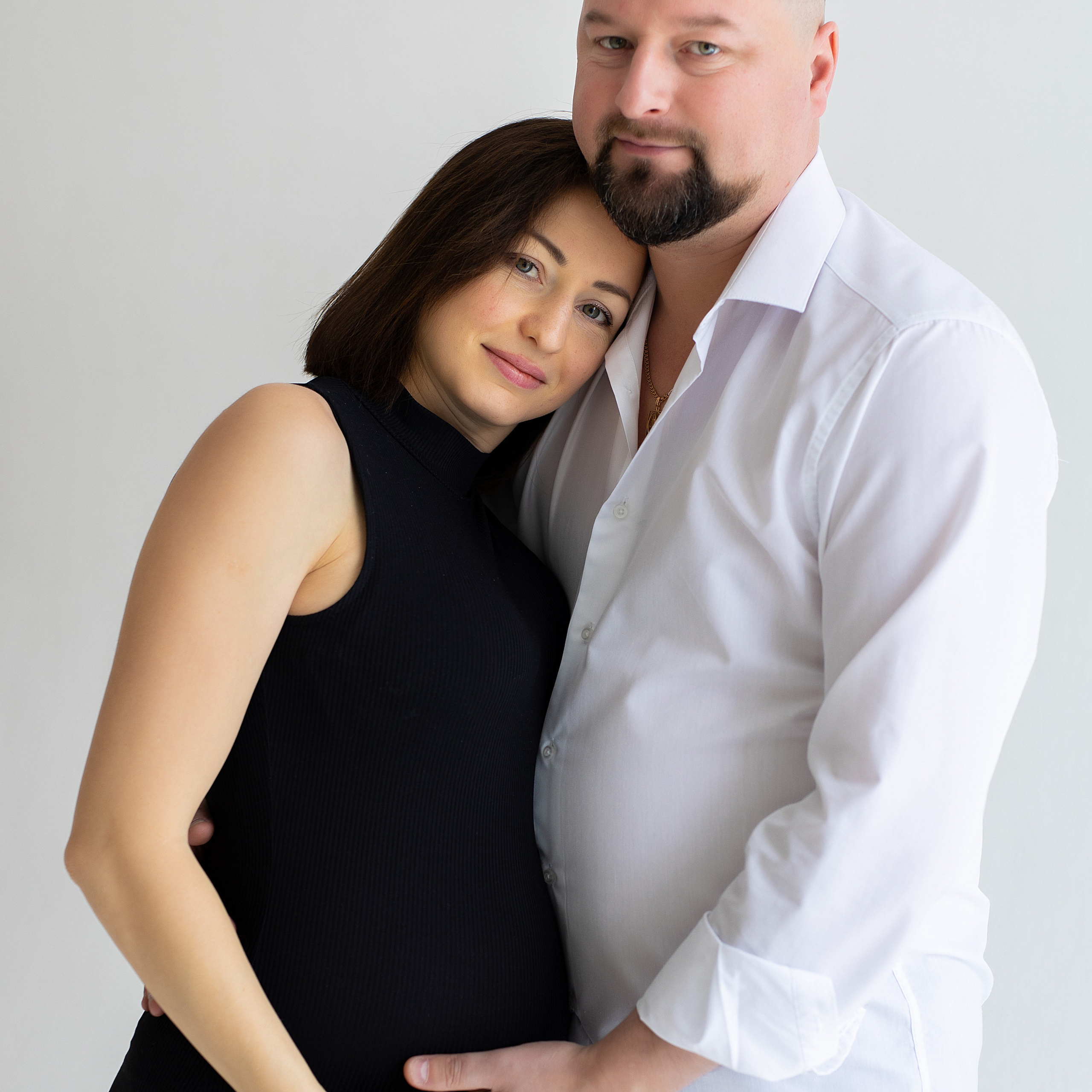 муж обнимает беременную жену