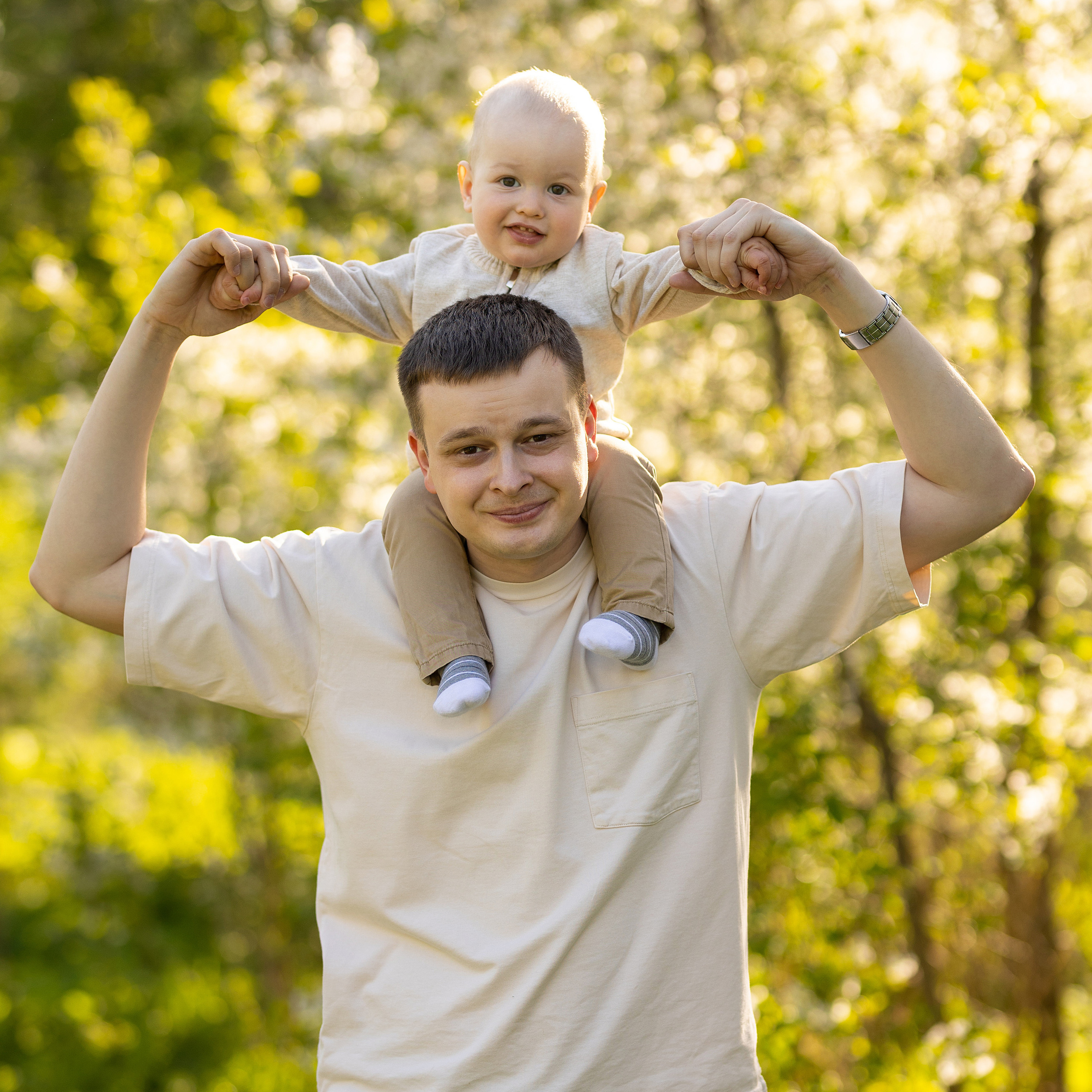 папа держит малыша на плечах