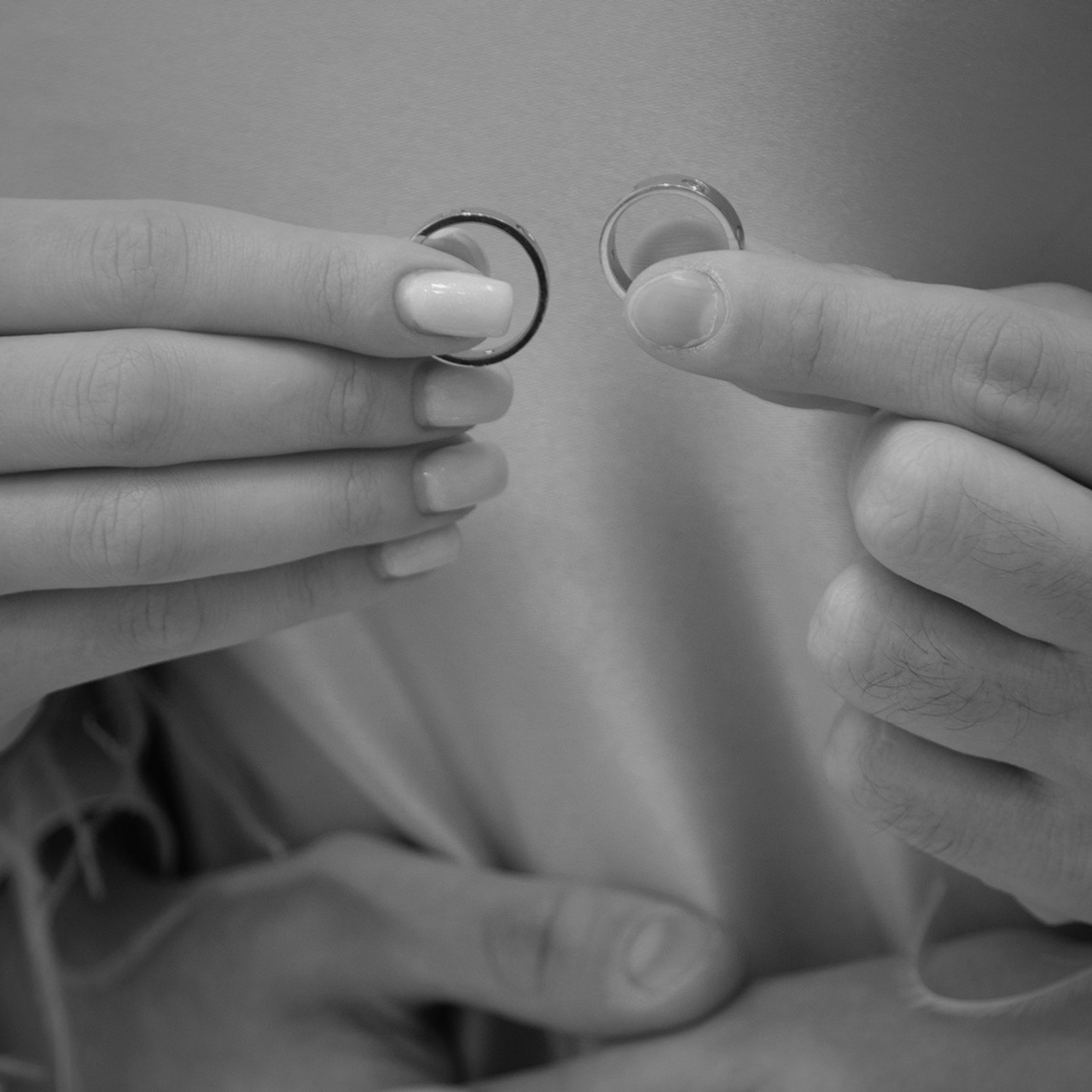 черно белое фото где фотограф снял как девушка держит обручальные кольца 