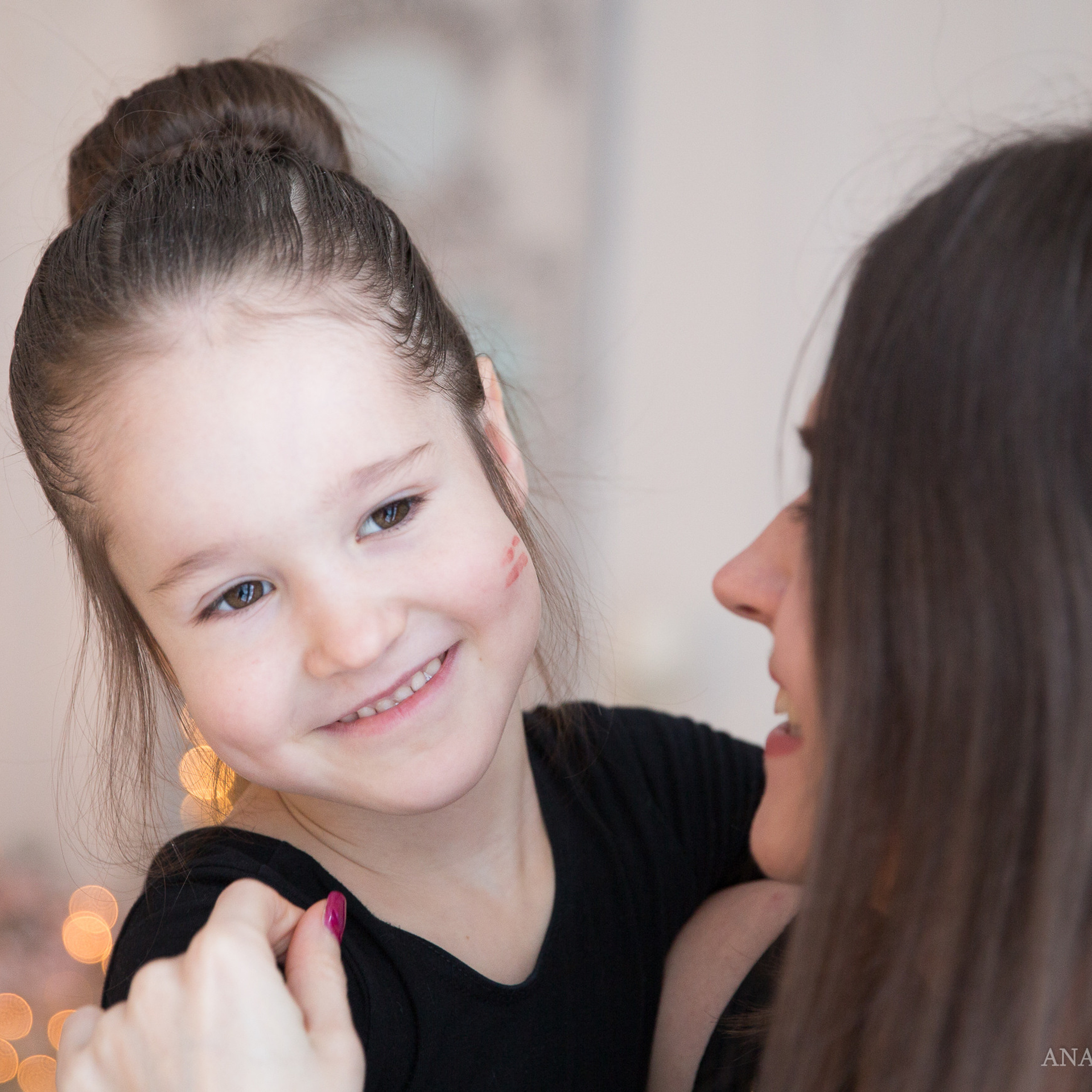 Фотосъемка мамы с дочкой в новогодней фотостудии Мимика, мама целует дочку в щечку, девочка смеется