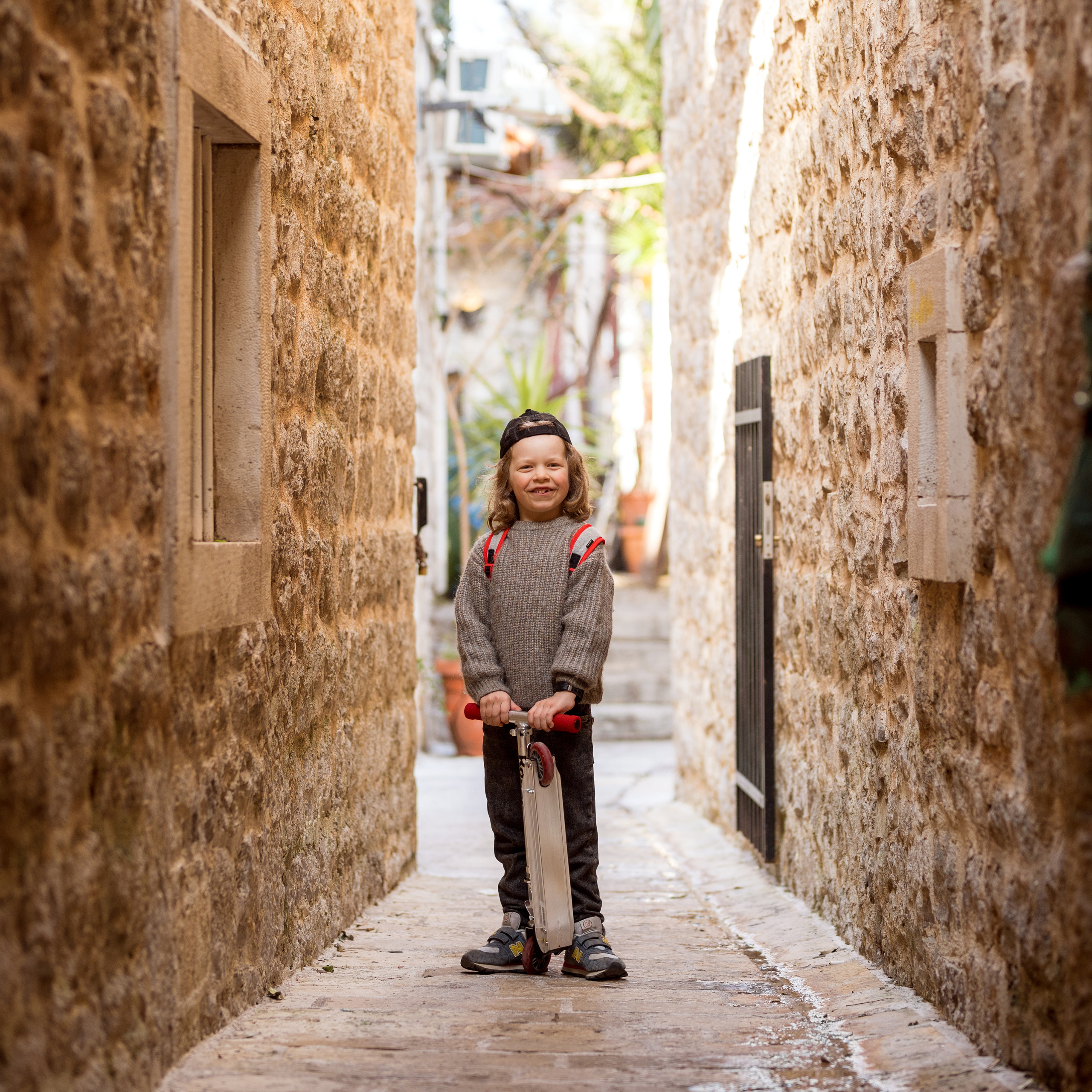 Photo session of a boy with a scooter in the old town of Budva