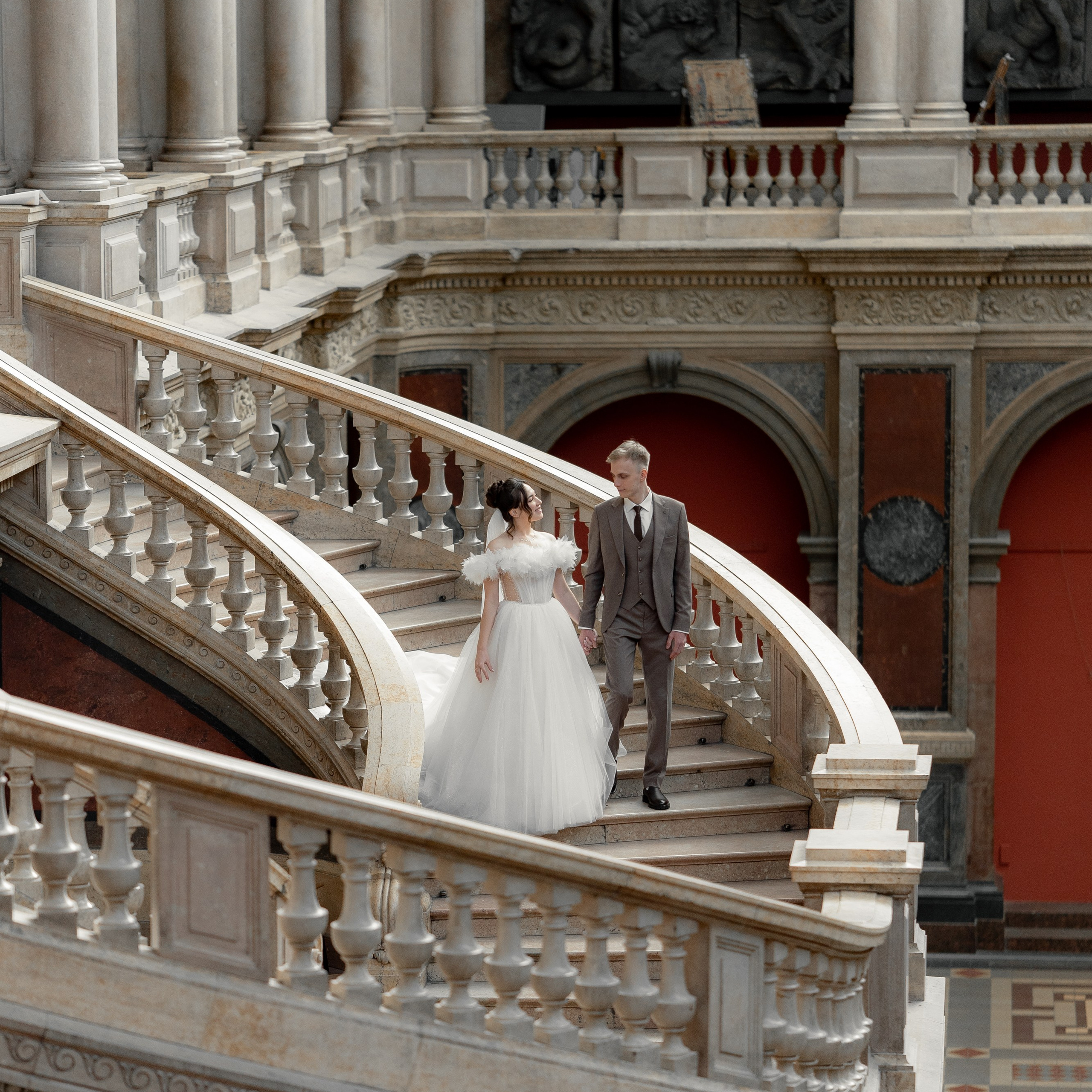 Свадебная фотосессия в академии Штиглица жених и невеста спускаются по главной лестнице