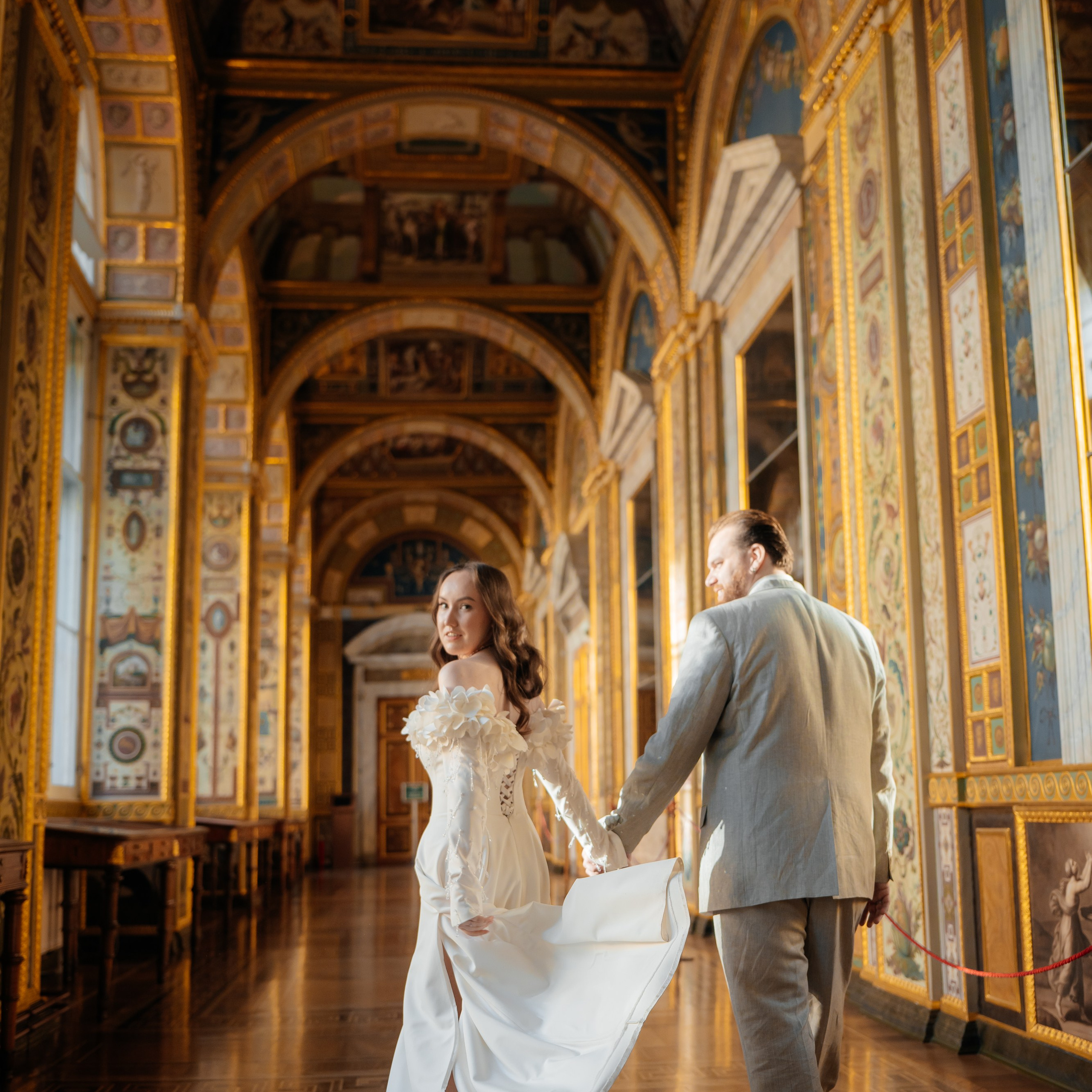 Примеры фото фотосессии в Эрмитаже жених и невеста идут за руку в Лоджиях Рафаэля